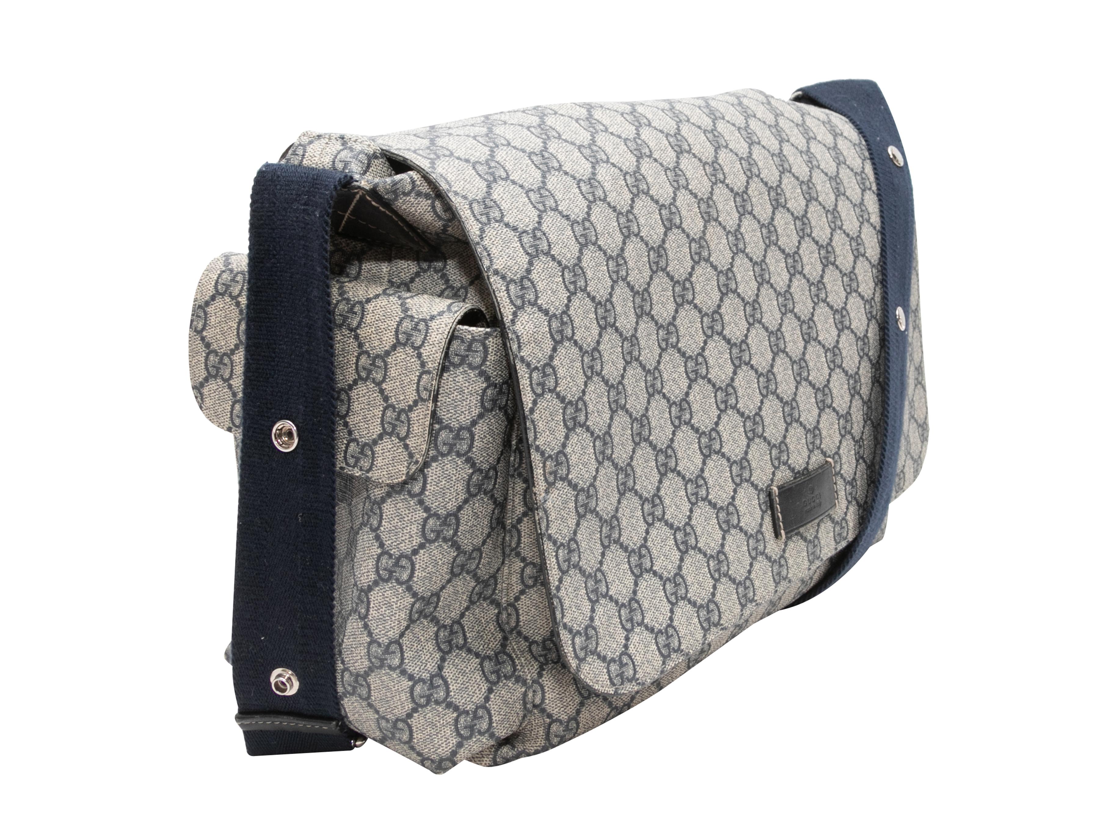 Grey & Navy Gucci GG Supreme Messenger Bag. This GG Supreme Messenger Bag features a coated canvas body, a single flat canvas strap, dual exterior flap pockets, an exterior back pocket, and a front flap closure. 16
