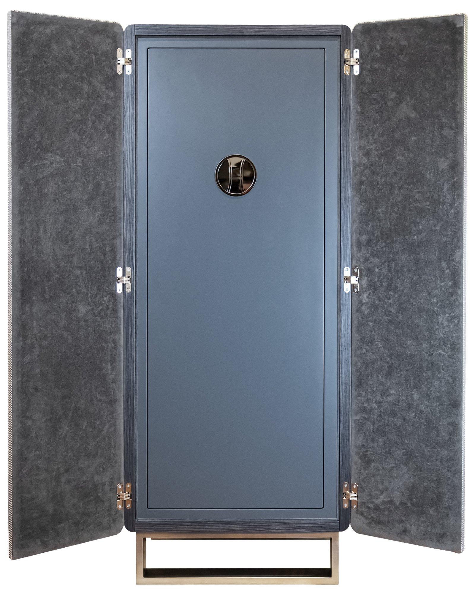 Fabrice con cassaforte in rovere grigio opaco, con ante rivestite in prezioso tessuto filato, che combina perfettamente sicurezza avanzata e design raffinato. Gli accessori in acciaio spazzolato e la base in acciaio spazzolato conferiscono al pezzo