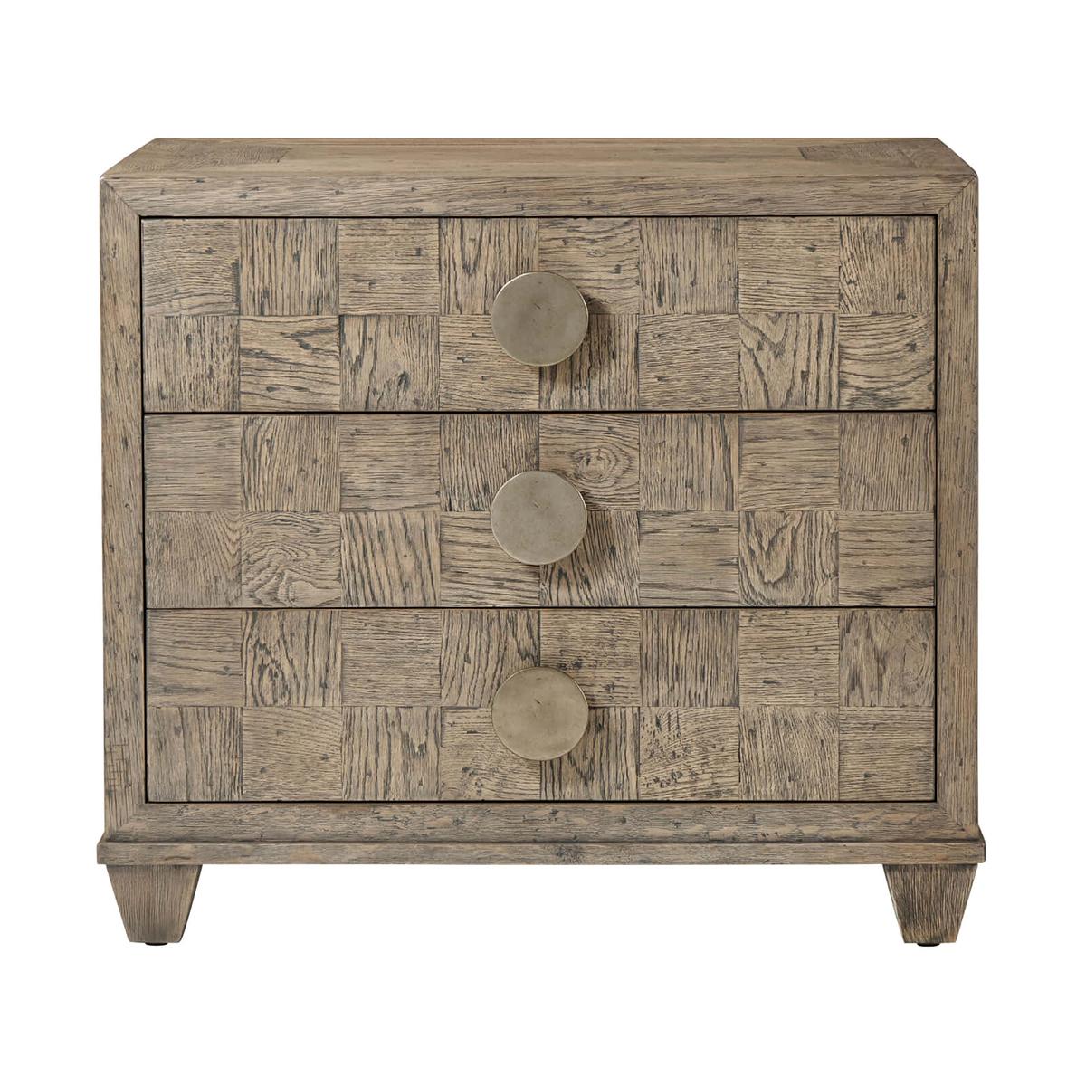 An Oak parquetry nightstand, handcrafted with rustic oak parquetry seen here in our Light Grey Echo Oak finish with picture frame parquetry top and sides. This nightstand includes three checkered parquetry soft-close drawers, vintage textured metal