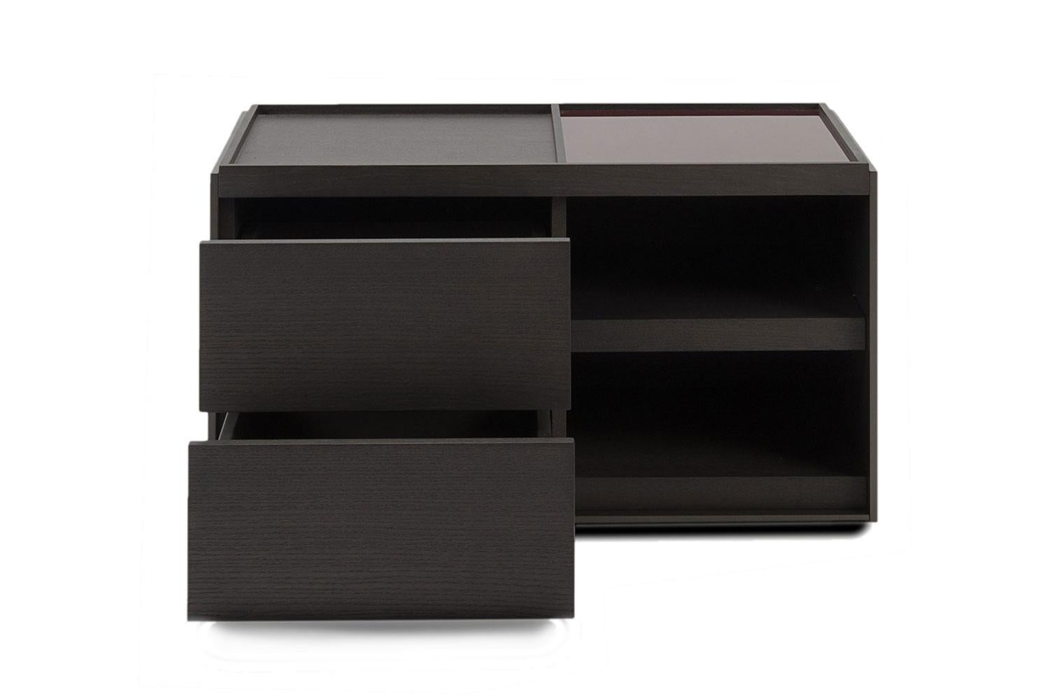 Surface storage unit side table By B&B Italia

This side table in grey oak wood from B&B Italia has two drawers and open compartments. A back lacquered plum colored piece of glass on one side of the surface and grey oak wood on the other. 
This