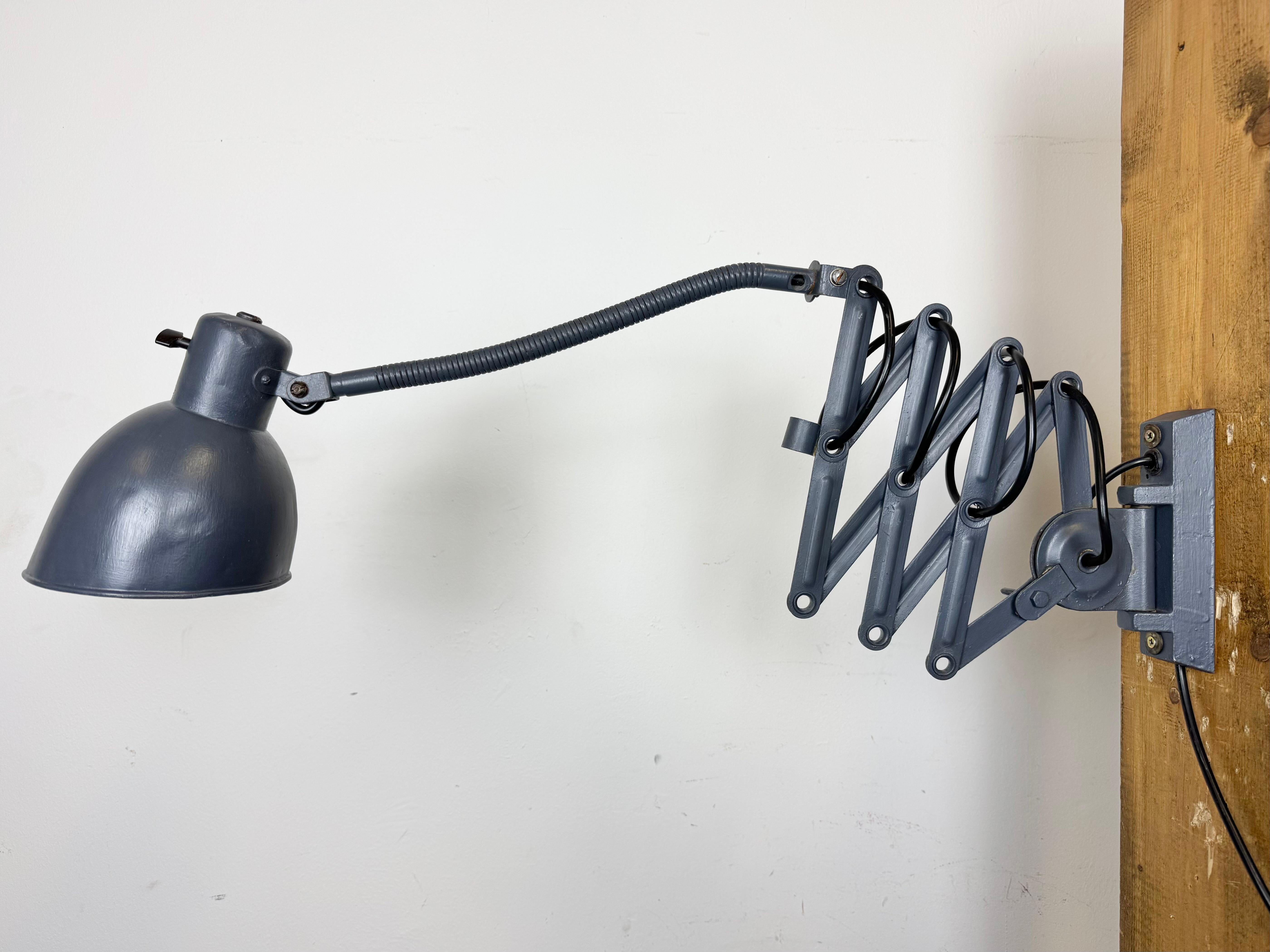 Diese verstellbare graue Vintage-Wandleuchte mit Schwanenhals wurde in den 1960er Jahren in der ehemaligen Tschechoslowakei hergestellt. Sie hat einen Lampenschirm aus Metall mit Drehschalter. Der eiserne Scherenarm ist ausziehbar und kann zur Seite