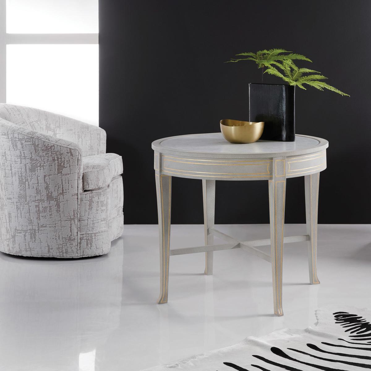 Our Painted Round Side Table showcases unparalleled attention to detail. The inset polished Cararra white marble top exudes opulence, elevating the aesthetic appeal of any space.

Its grey painted finish adds a soft touch, while the gold leaf trim