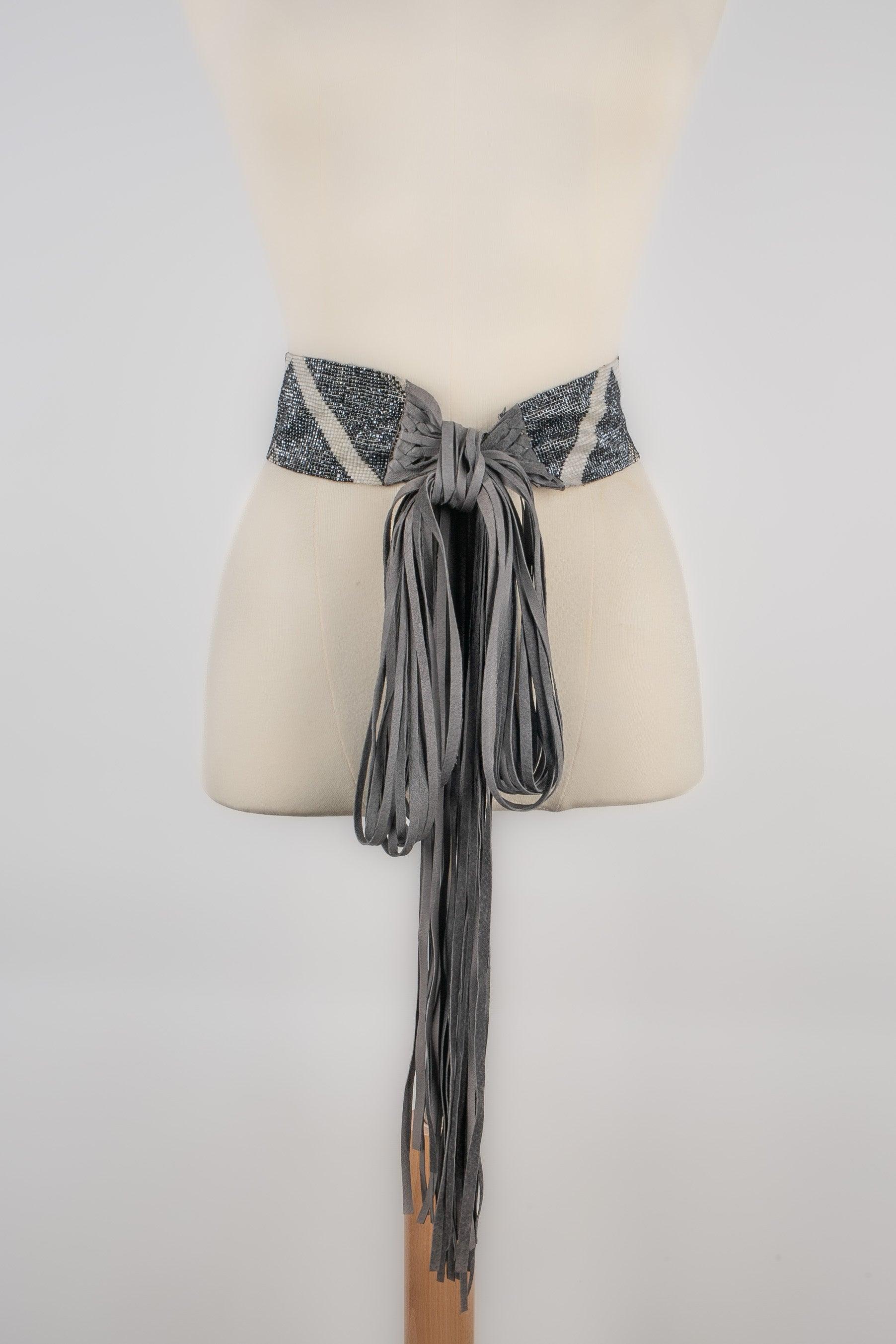 Pearl belt in grey and white tones ornamented with leather fringes. Not signed.

Additional information:
Condition: Very good condition
Dimensions: Length: 54 cm - Length with the fringes: 260 cm

Seller Reference: ACC230
