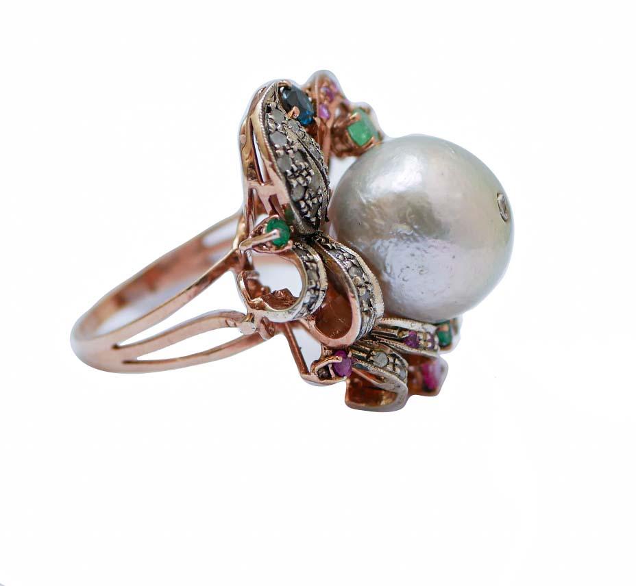 Retrò ring in 9 kt rose gold and silver structure mounted with a central pearl with a diamond on it surrounded by diamonds,emeralds, rubies and sapphires.
This ring was totally handmade by Italian master goldsmiths and it is in perfect