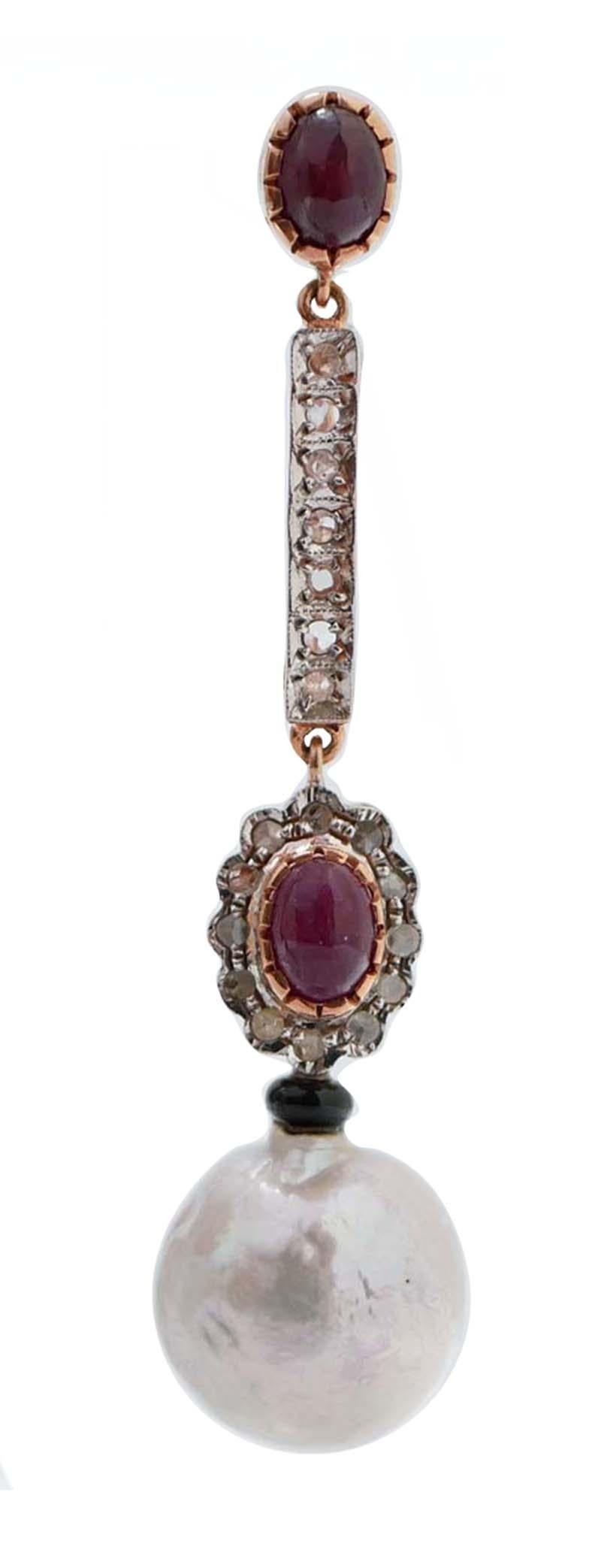 Fantastic dangle earrings in 9 kt rose gold and silver structure mounted with a ruby in the upper part. In the middle, diamonds and a flower of diamonds with a central ruby. Below, an onyx and a grey pearl.
These earrings were totally handmade by