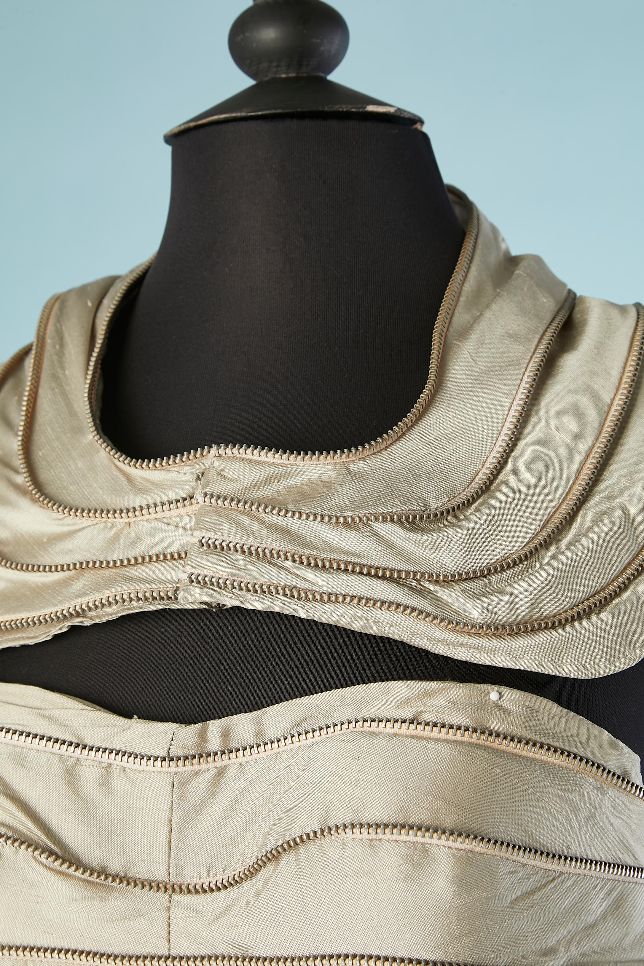 Vestido de noche bustier de seda cruda gris con adorno de cremallera y cuello de tela. 
No hay etiqueta de composición del tejido, pero el forro probablemente sea de poliéster o rayón. 
Sujetador ligeramente acolchado. Cierre de corchete detrás del