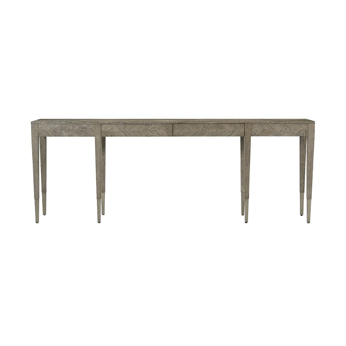 A rustic parquetry inlaid long console table with a rustic grey echo finish. With two drawers raised on six square tapered oak legs with vintage textured metal feet.
Dimensions: 88