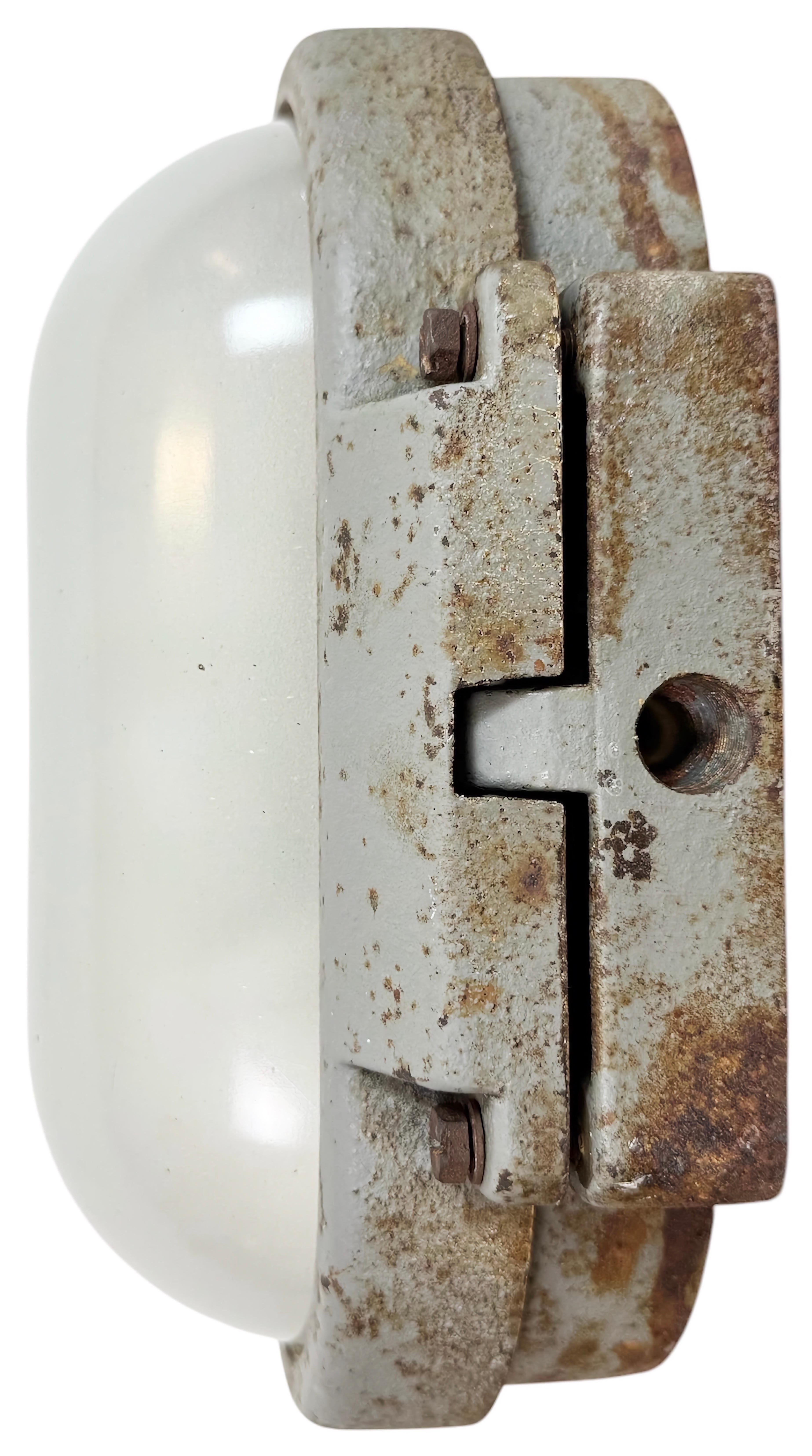 Industrial wall light made by Elektrosvit in former Czechoslovakia during the 1960s. It features a cast iron body and a milk glass cover. The porcelain socket requires E27 / E26 light bulbs. New wire. The weight of the light is 5,8 kg.