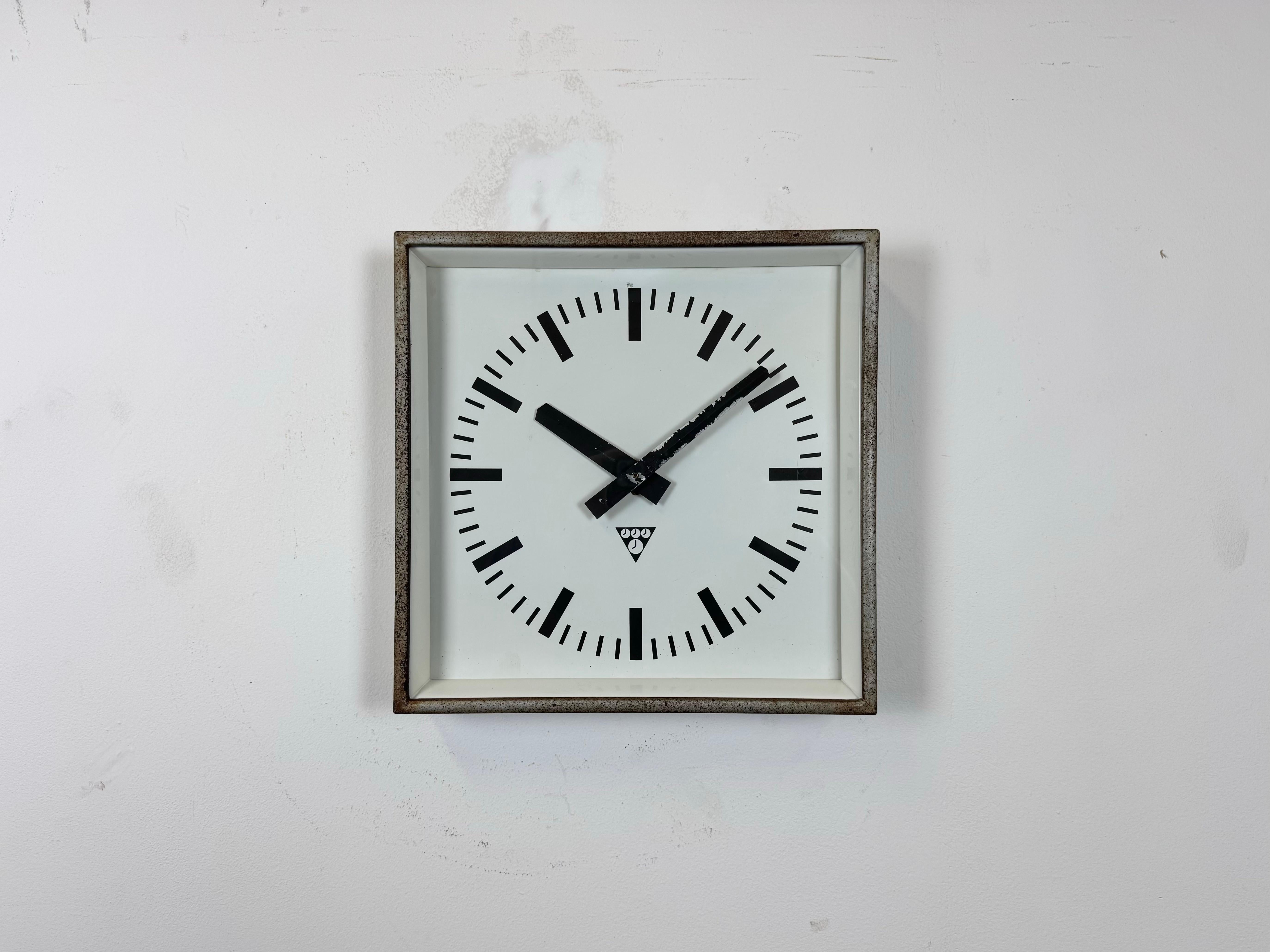 - Horloge murale conçue par Pragotron dans l'ancienne Tchécoslovaquie au cours des années 1970 et fabriquée jusque dans les années 1990.
- Utilisé dans les usines, les écoles et les gares. 
- Cadre en métal gris avec une patine rouillée