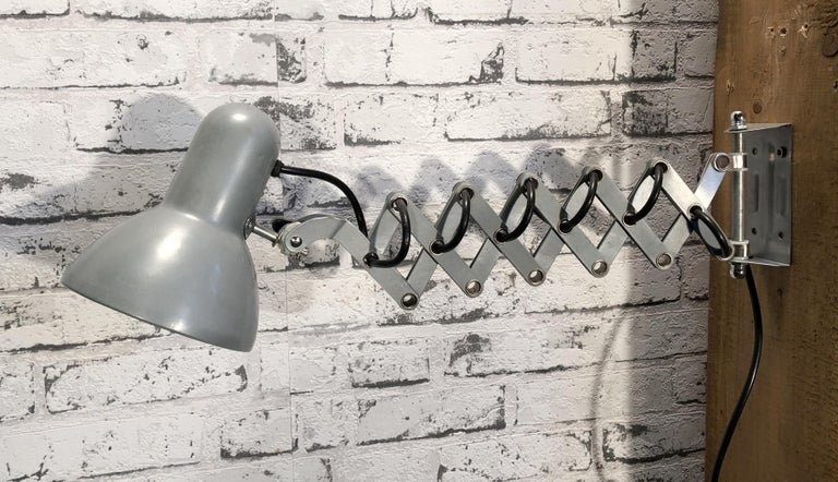 Vintage industrial scissor wall lamp manufactured during the 1980s..Lamp has grey lampshade. Scissor arm is extendable and can be turned sideways. Socket for E 27 bulbs. Fully functional. 
Dimensions: 
Scissor: approx. 32 cm to 64 cm (maximum