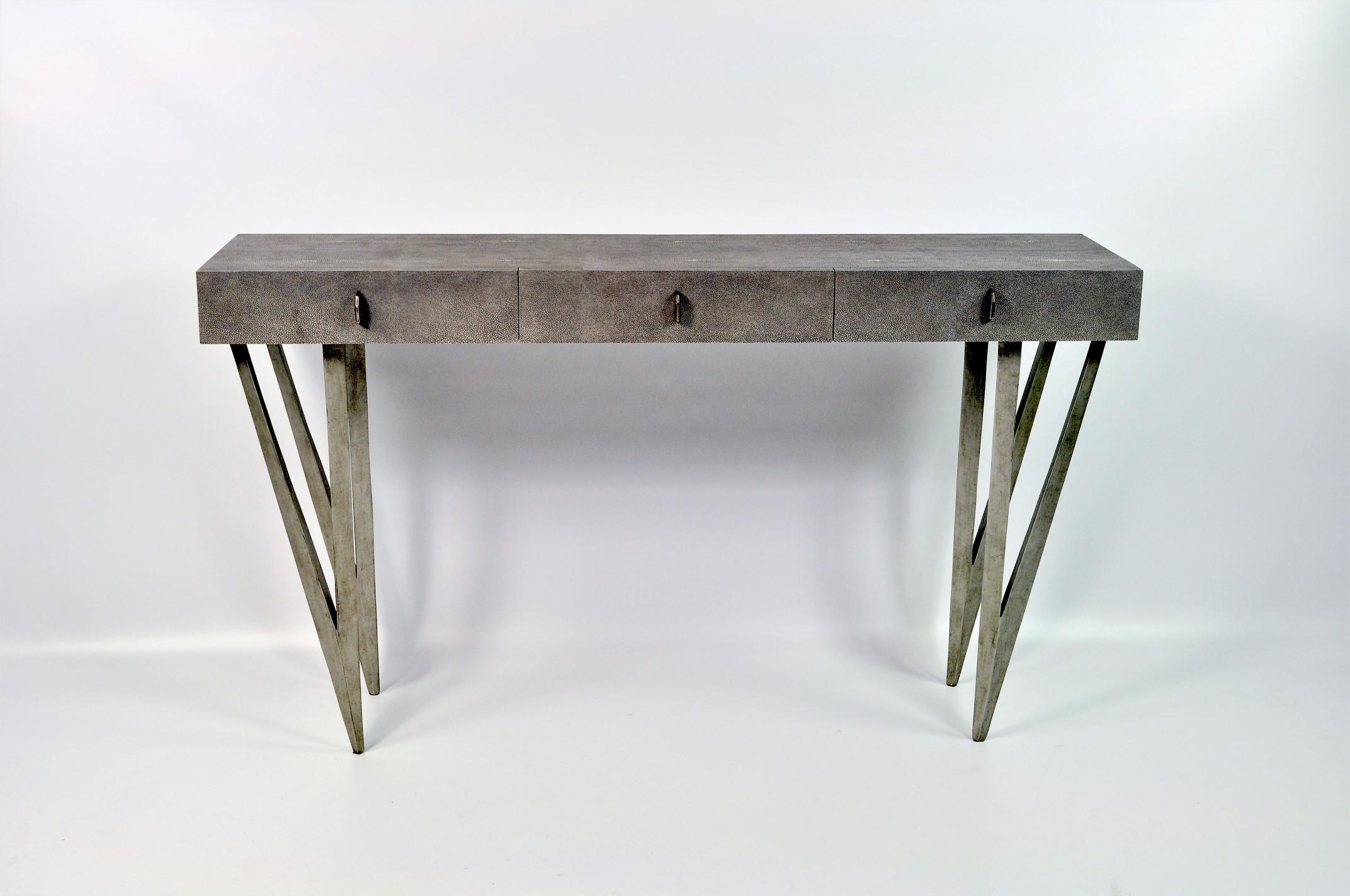 The console table reef is made of dark grey shagreen (our ref CARBON).
It has three drawers and the legs have an old silver patina.
The knobs are made in lost wax cast brass.

This console will settle very well in your entrance or your living