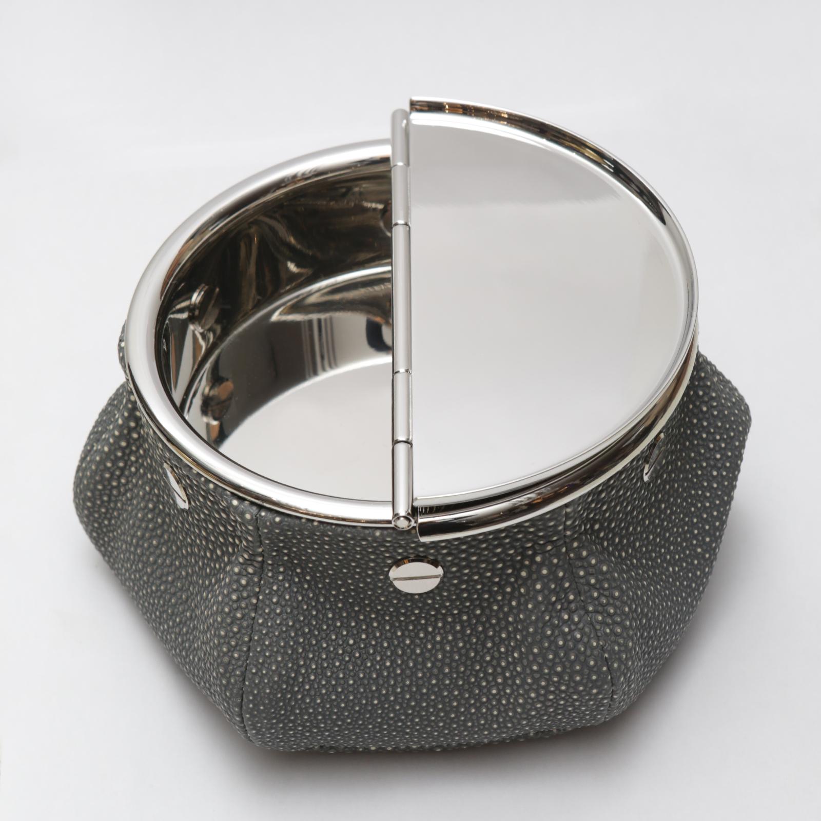 Ashtray grey sharkskin 2 cigars yachting with bag covered
with grey shagreen finish printed on calfskin with grey stitching.
Bag filled with 1 kg micro metal balls that give high stability.
Ashtray top with 2 openable lids in solid brass in