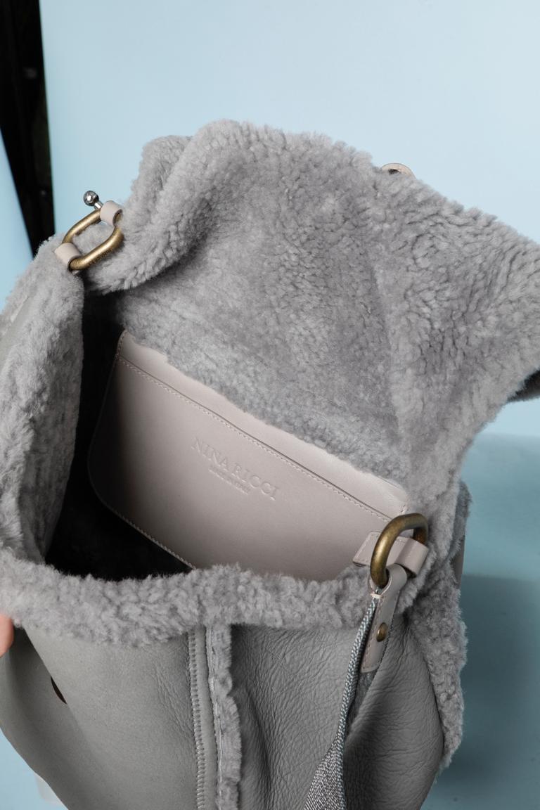 Grey shearling shoulder bag with nylon and thread strap. Top stitched. No lining. 
Size 35cm X 50cm. One outside pocket with zip and one flat pocket in leather inside. 
Snap to close it. 