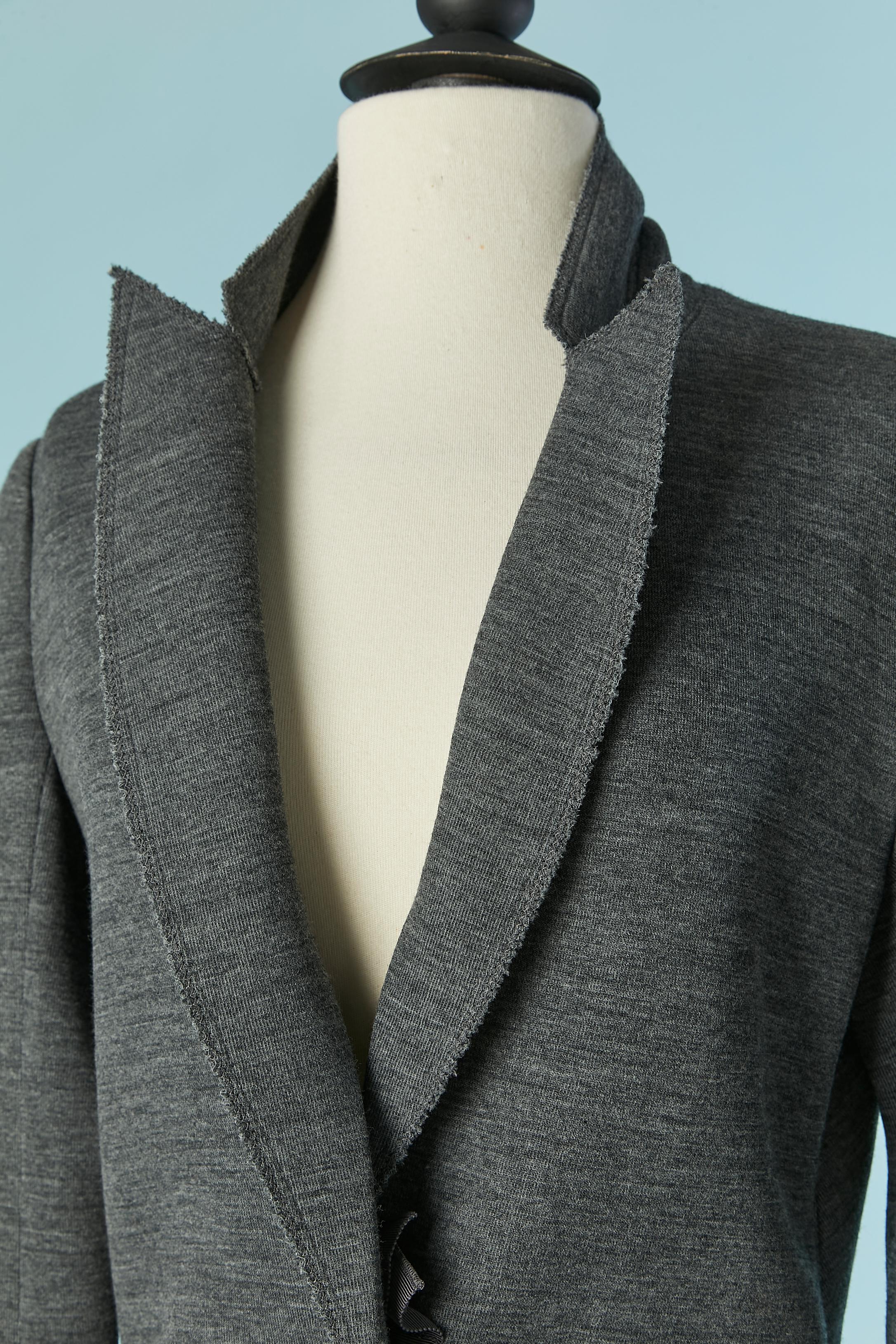 Veste grise à simple boutonnage avec fermeture à bouton-pression cachée. Composition du tissu : 78% laine, 22% polyamide. Pas de doublure. Fermeture par bouton-pression caché sur le gros grain. Pochette sur les deux côtés. 
TAILLE 40 (Fr) M 