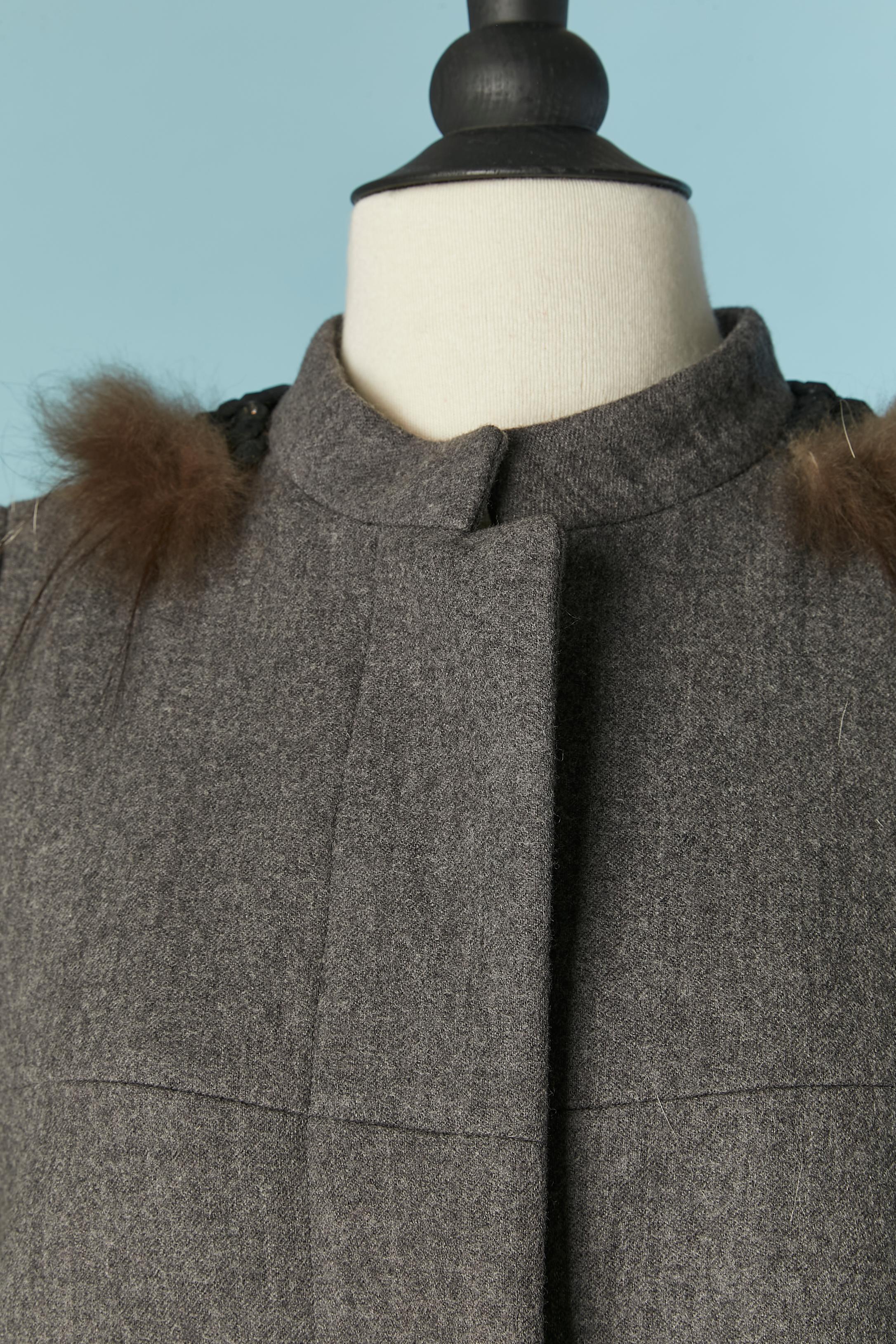 Cappotto monopetto grigio in lana con pelliccia e collo in perline. Fodera in seta. 
Chiusura con bottoni nascosti e asole al centro del davanti. Taglio e lavorazione. Tasca su entrambi i lati.
TAGLIA 40 (It) 36 (Fr) S 