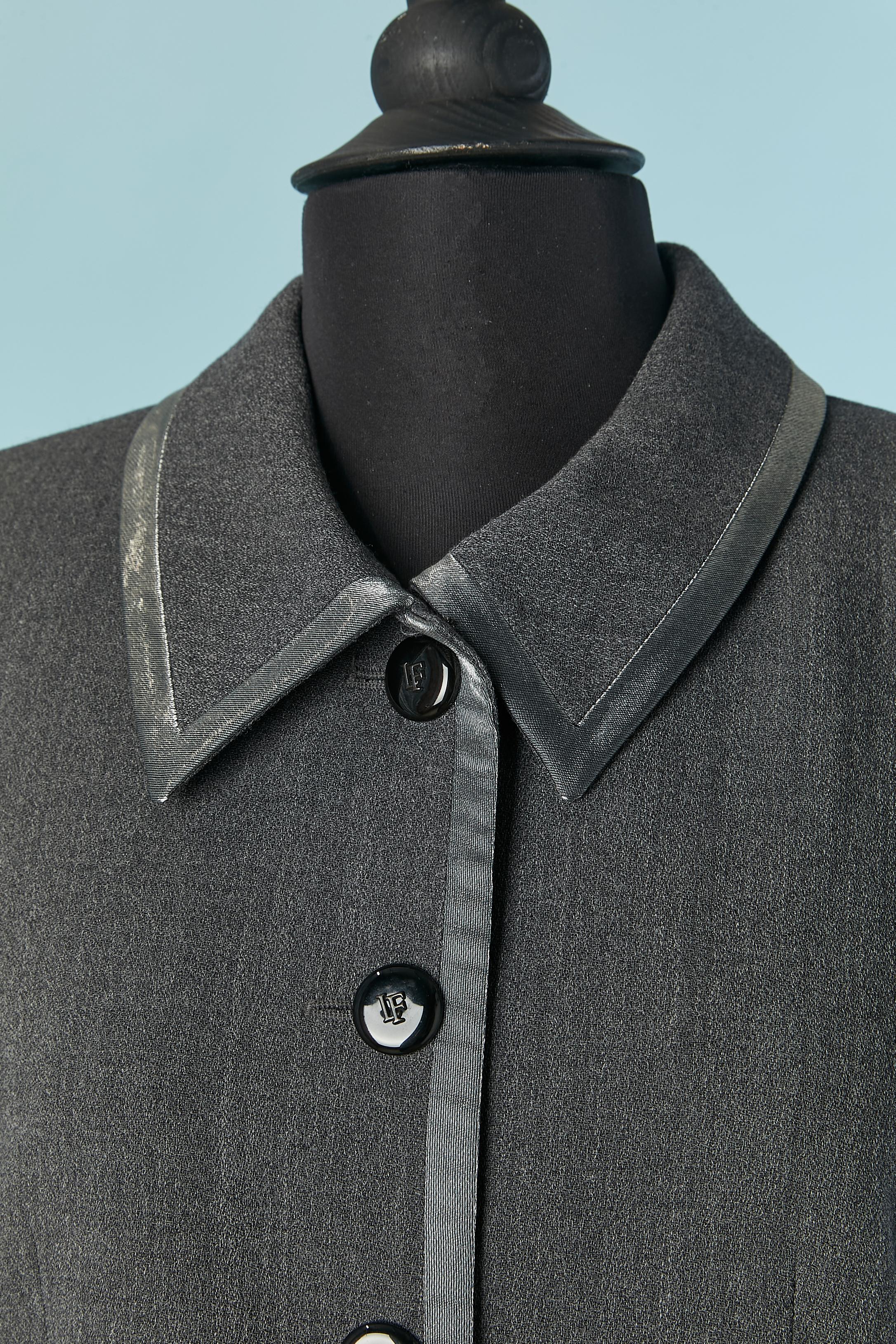 Grey skirt suit with shiny fabric edge. Main fabric composition: 100% wool. Shiny fabric composition: 85% silk, 15% nylon. Lining composition: 54% rayon, 46% polyester. 
Shoulder pad. Branded button and buttonhole closure on the middle front and on
