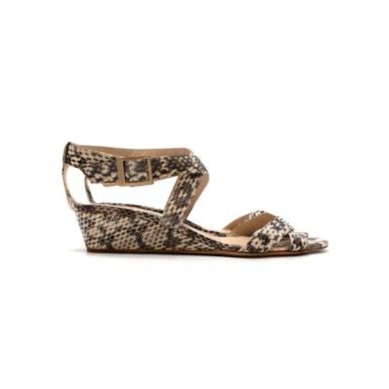 Jimmy Choo Grey Snake Skin Wedge Sandals
 
 - Snakeskin embossed polished leather sandals with a small wedge heel
 - Gold tone buckle fastened twist fastening around the ankle
 - Twisted straps over the toes
 - Logo branded fabric patch 
 
