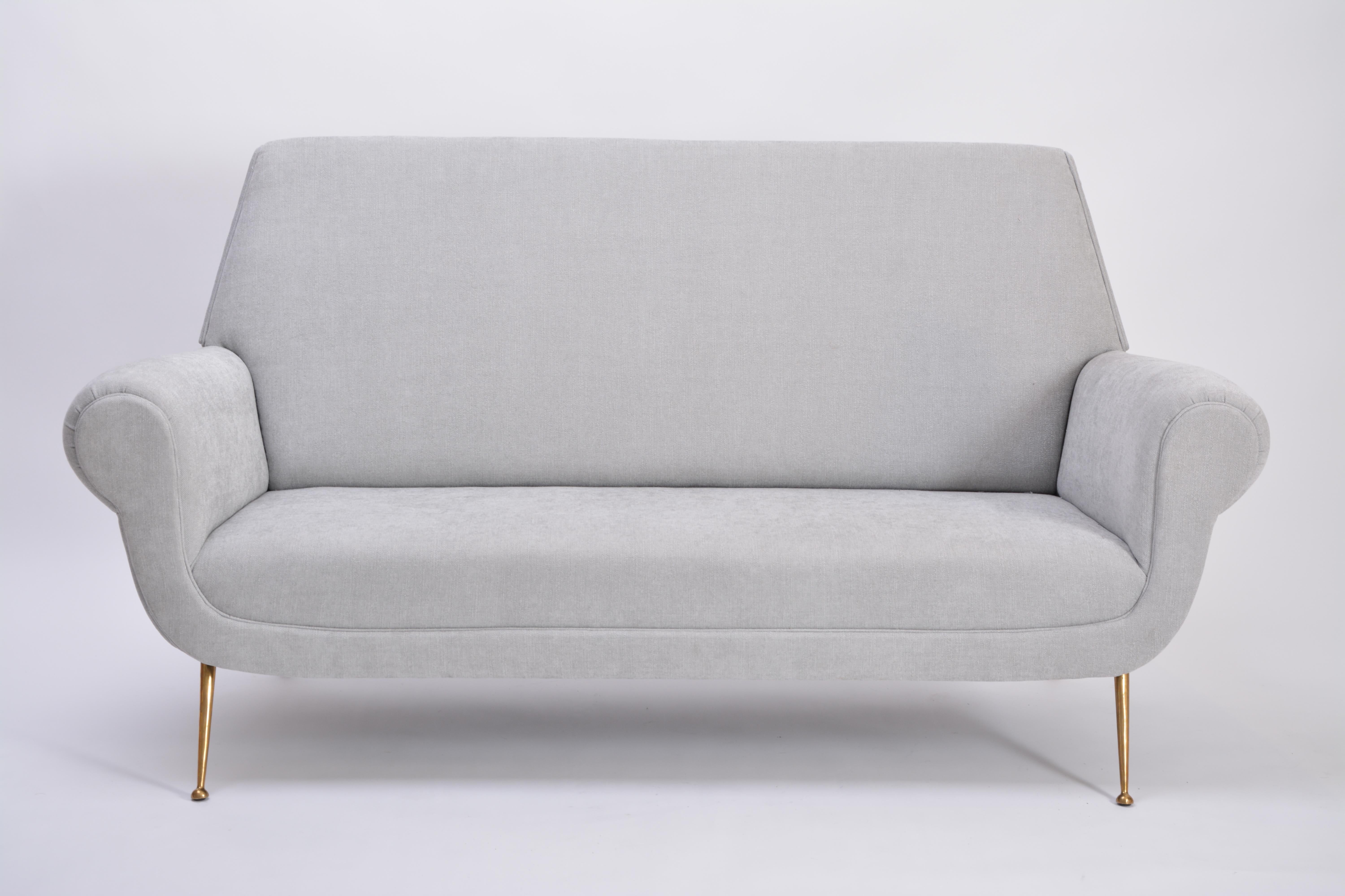 This sofa was designed by Gigi Radice for Minotti in the 1950s. It has been upholstered and features brass legs. It is in excellent vintage condition. 