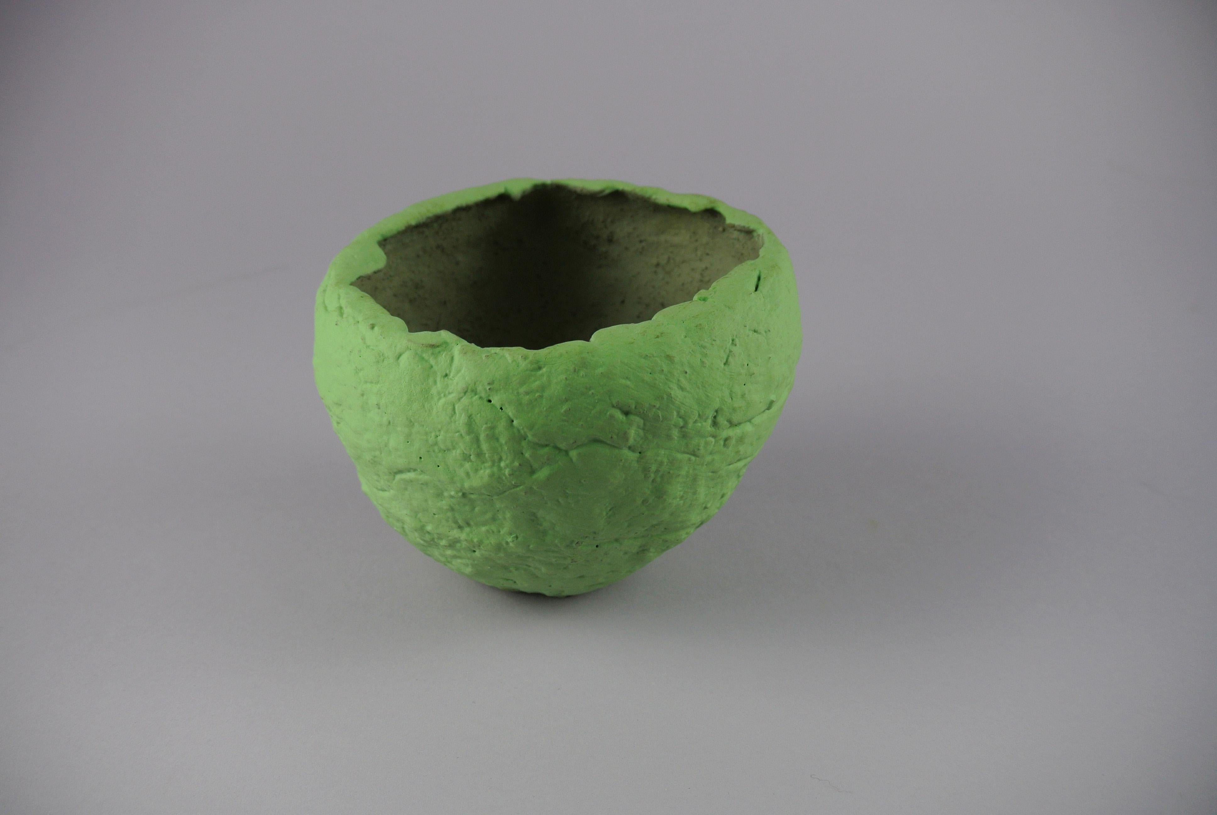 Rough grey stoneware plant vessel with matte lichen green engobe and visible fire sand texture.
The vessel has a hole in the bottom for drainage.