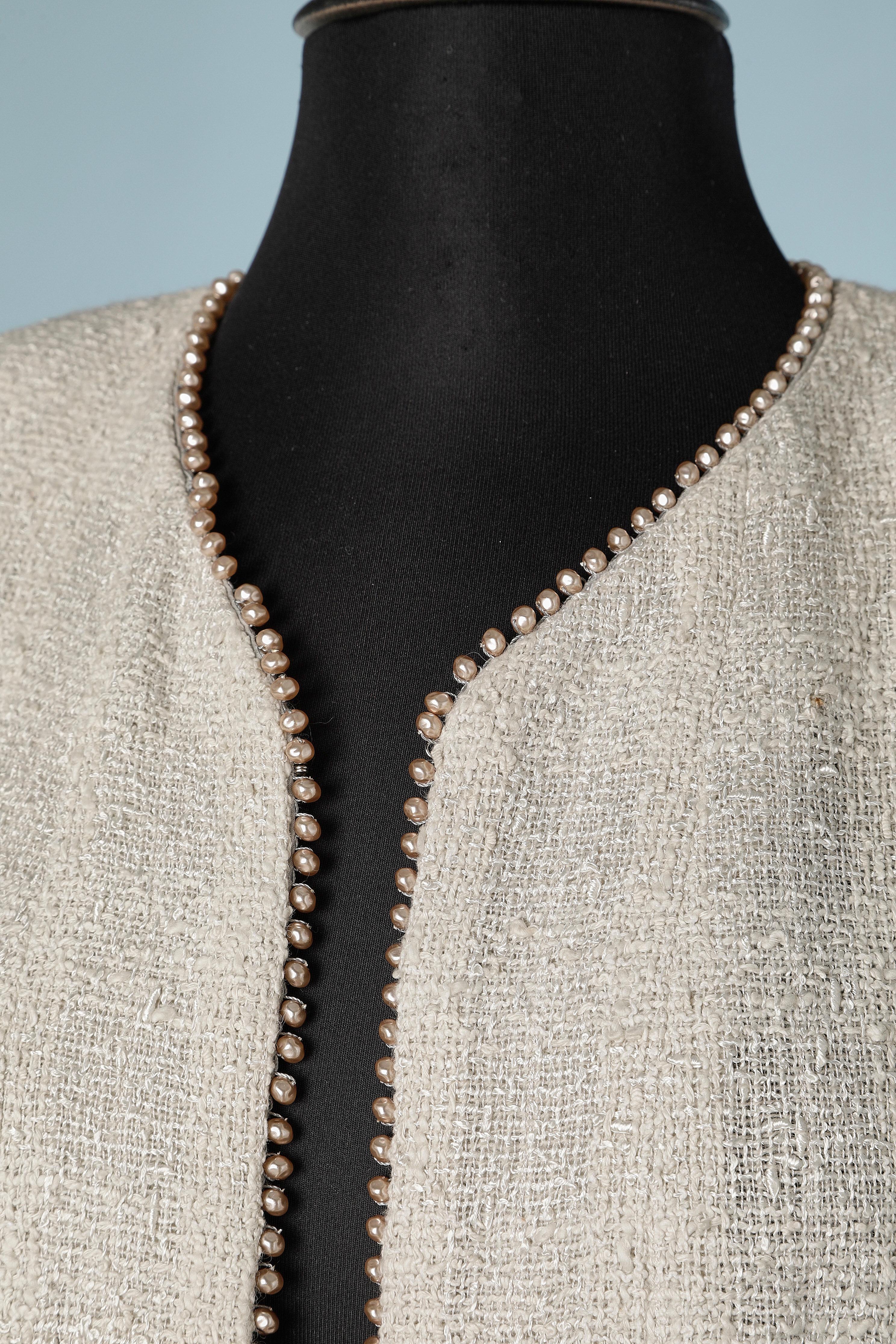 Grey tweed jacket with mother of pearls beads on the edge. Cotton lining. 
Shoulder pads. Metallic chain in the inside bottom edge. 
SIZE 42 (L) 