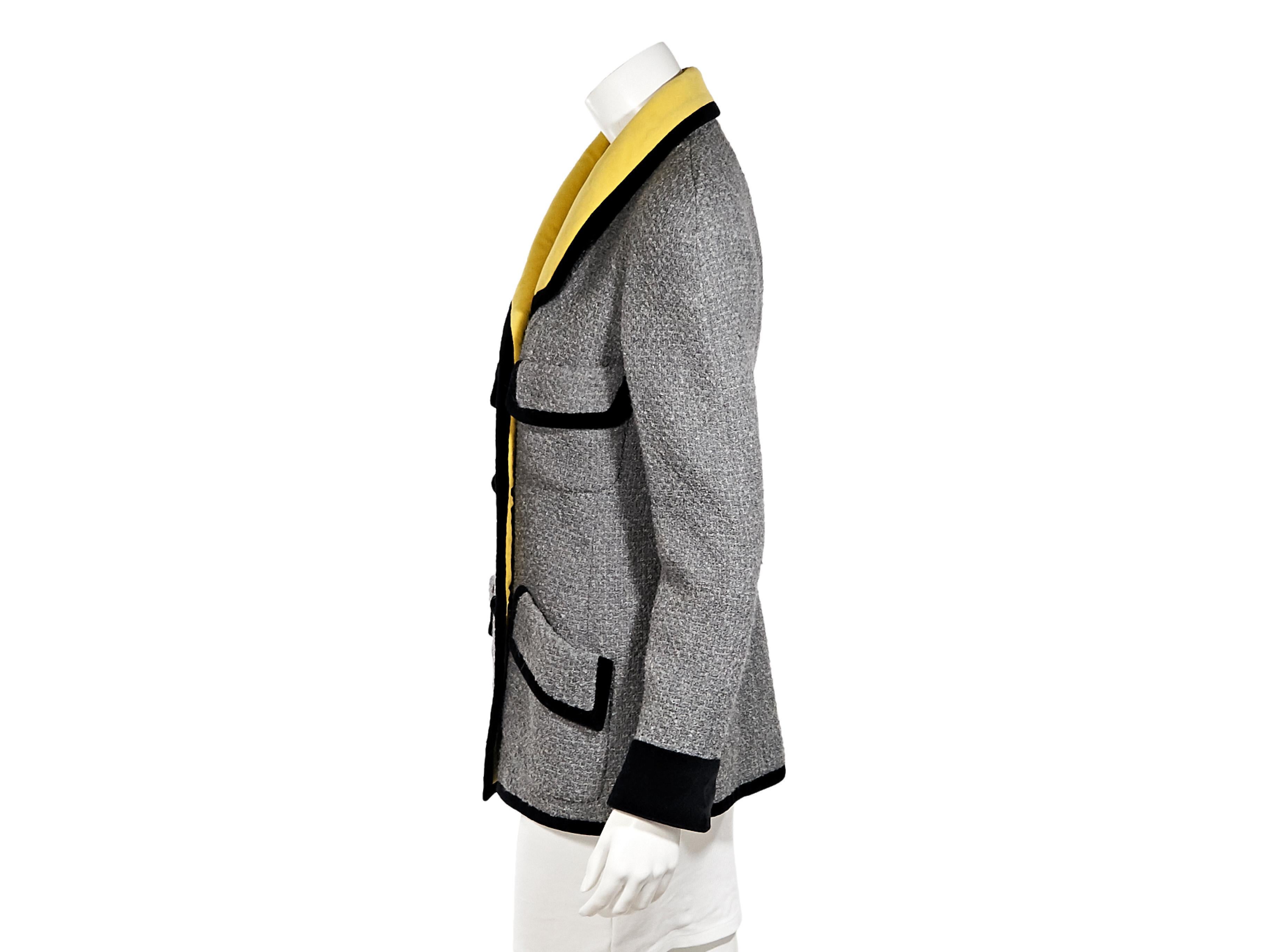 Product details:  Vintage grey tweed jacket by Chanel.  Trimmed with black velvet.  Spread yellow collar.  Long sleeves.  Double-breasted button-front closure.  Four front flap pockets.  34