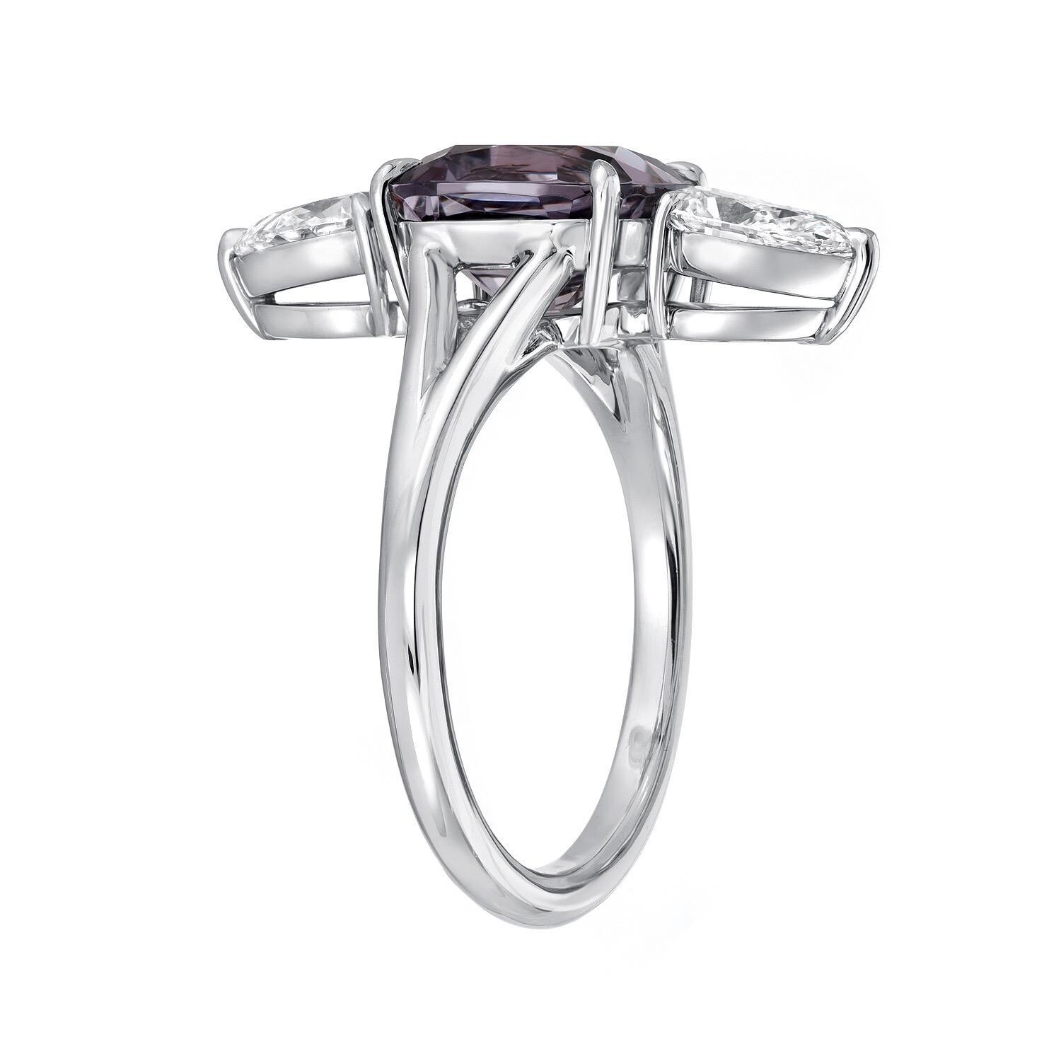 Spectacular 3.14 carat cushion cut Burma Spinel, displaying a violet hue with grayish undertones, and a pair of GIA certified F/VS1 pear shape diamonds weighing a total of 1.00 carat, are set vertically in this exquisitely hand crafted platinum