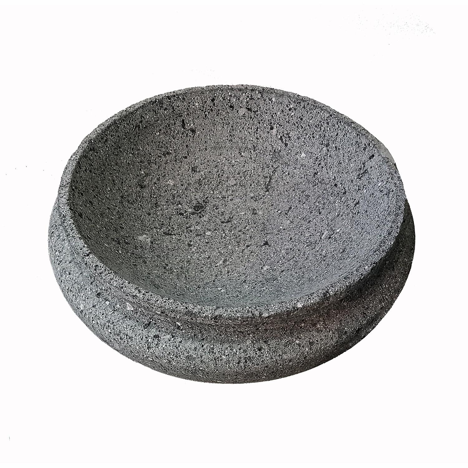 A dark lava stone bowl in a round, shallow shape, hand-crafted in Mexico. An organic modern accent to home décor, in the kitchen, living room or any other area, indoors or outdoors. Its softly rounded edges allow the texture of stone to take center