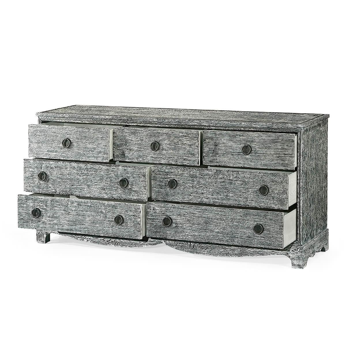 An unusual country grey washed wenge seven drawer dresser with iron trim and ring handles raised above a scalloped apron and bracket feet.

Dimensions: 72