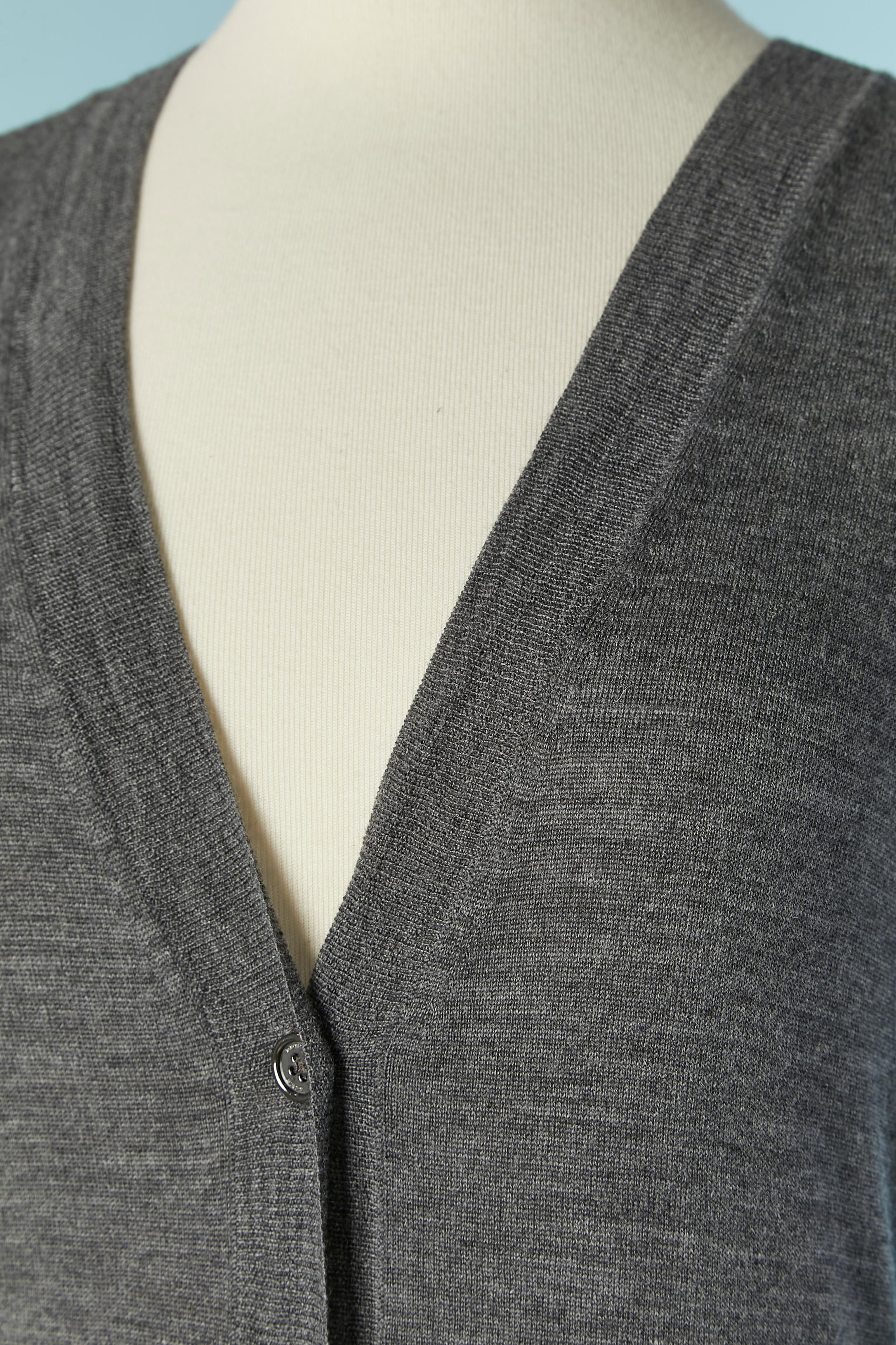 Cardigan en laine grise avec fermeture à bouton de marque sur le milieu du devant. Un bouton supplémentaire est fourni. 
NOUVEAU avec étiquette 
TAILLE S / 36 (Fr) 
