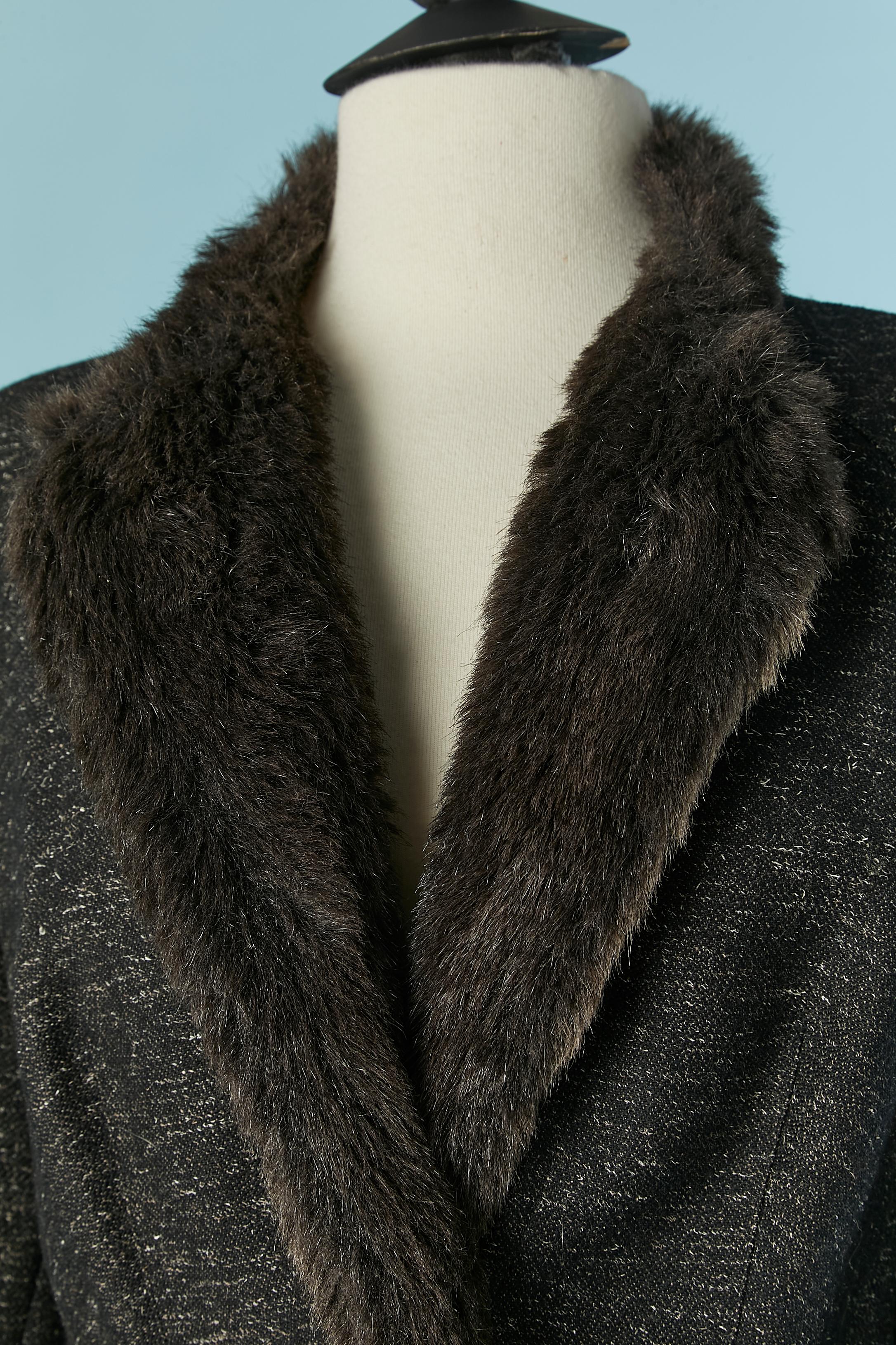 Grey wool chiné skirt suit with faux fur edge. Acetate lining. Shoulder pad . Raglan sleeve. Hidden snap closure on the middle front. Pocket on both side. 
Jacket size : 44 (Fr) L 
Skirt size : 44 (Fr) but fit M 