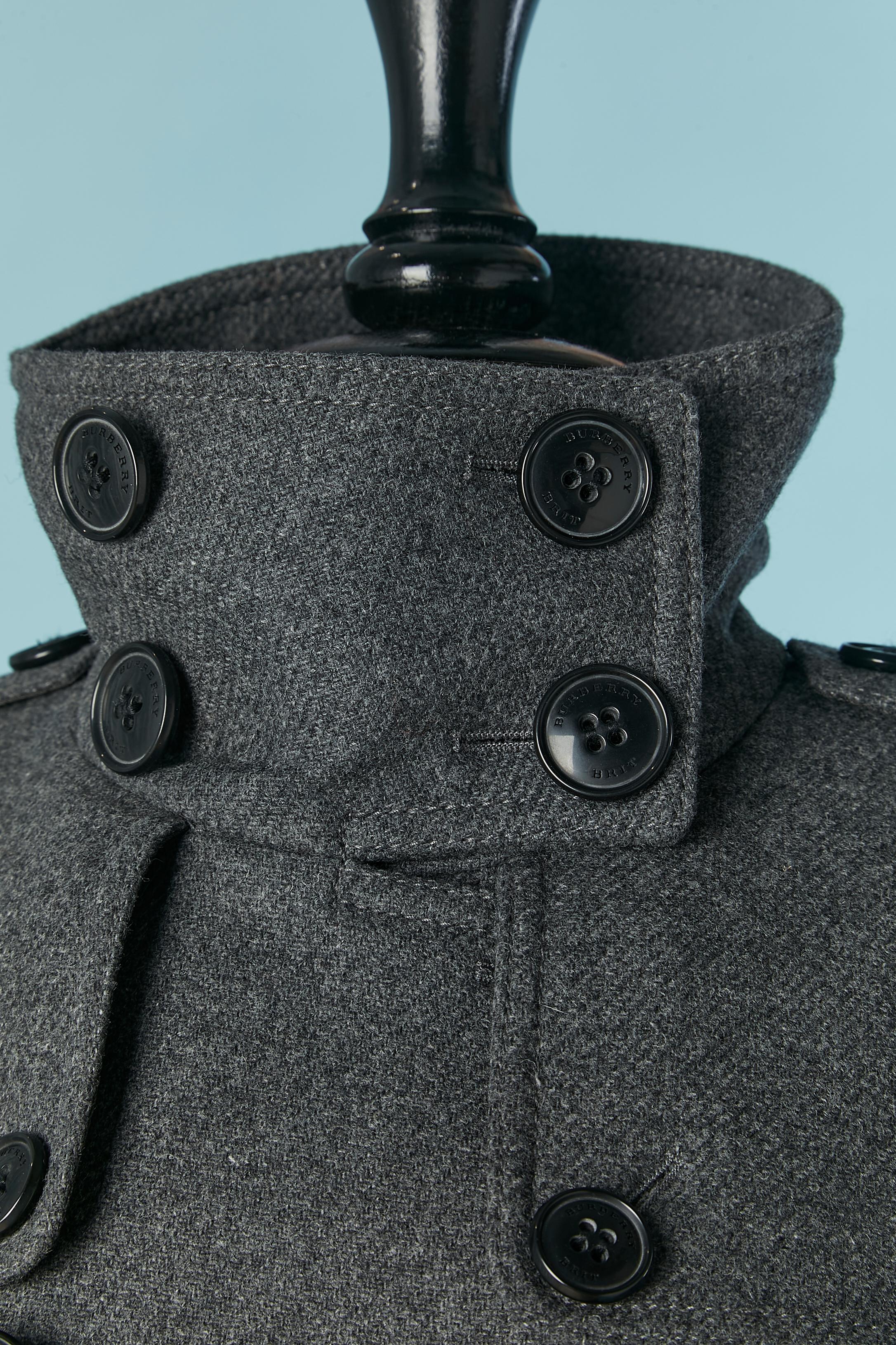 Grey wool double-breasted coat with belt. 
Shell fabric composition: 70% wool, 25% nylon, 5% cashmere. Upper body lining composition ( with check pattern) : 54% cotton, 37% acetate, 9% cupro. Lower body lining composition: 100% rayon. 
Shoulder pad.
