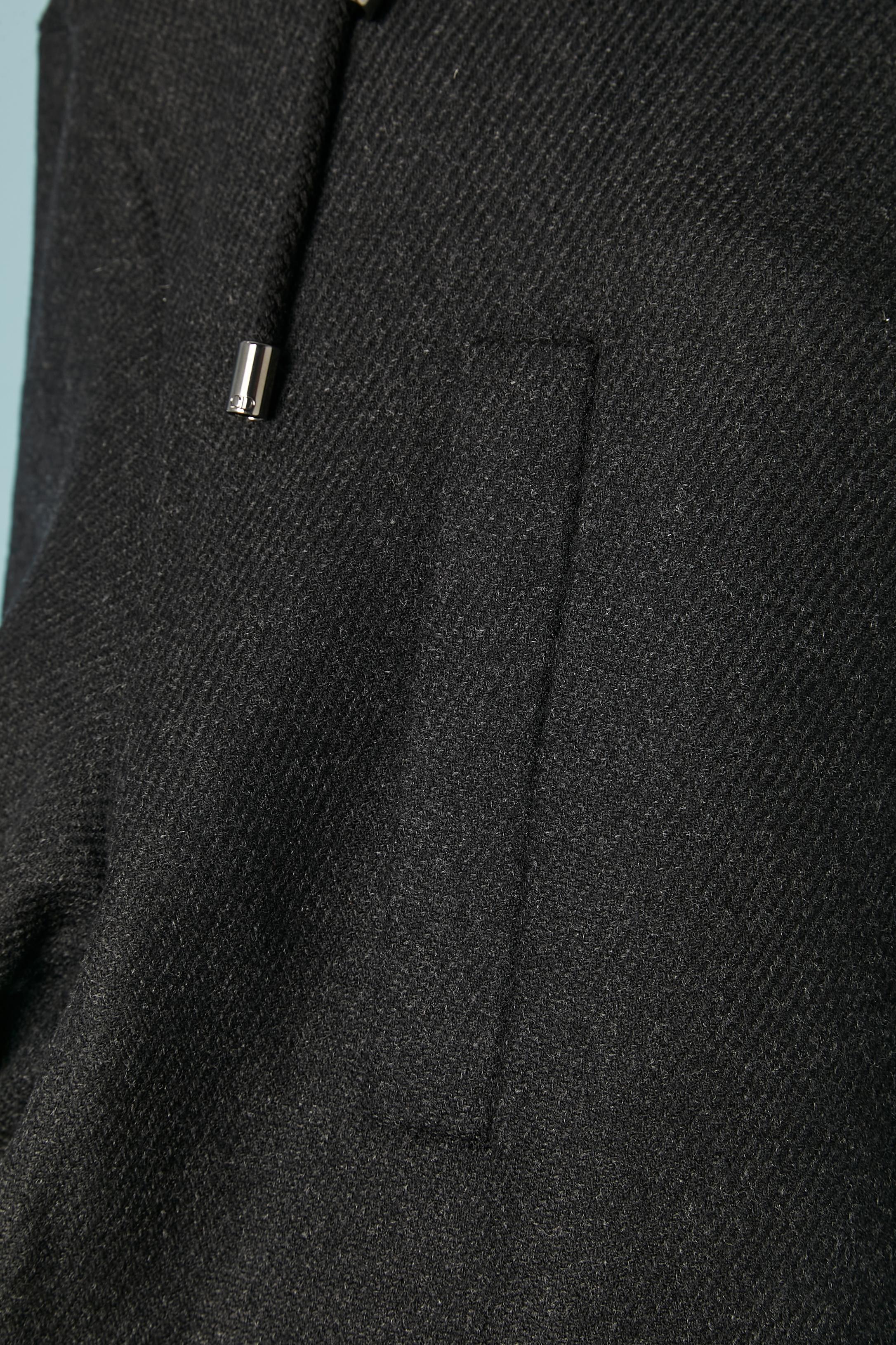 Cappotto double-face in lana grigia con cappuccio con zip e coulisse sul bordo del cappuccio. Chiusura con zip nascosta e bottoni automatici al centro della parte anteriore. 4 tasche sul davanti con chiusura a scatto. Bottone e asola con marchio sui