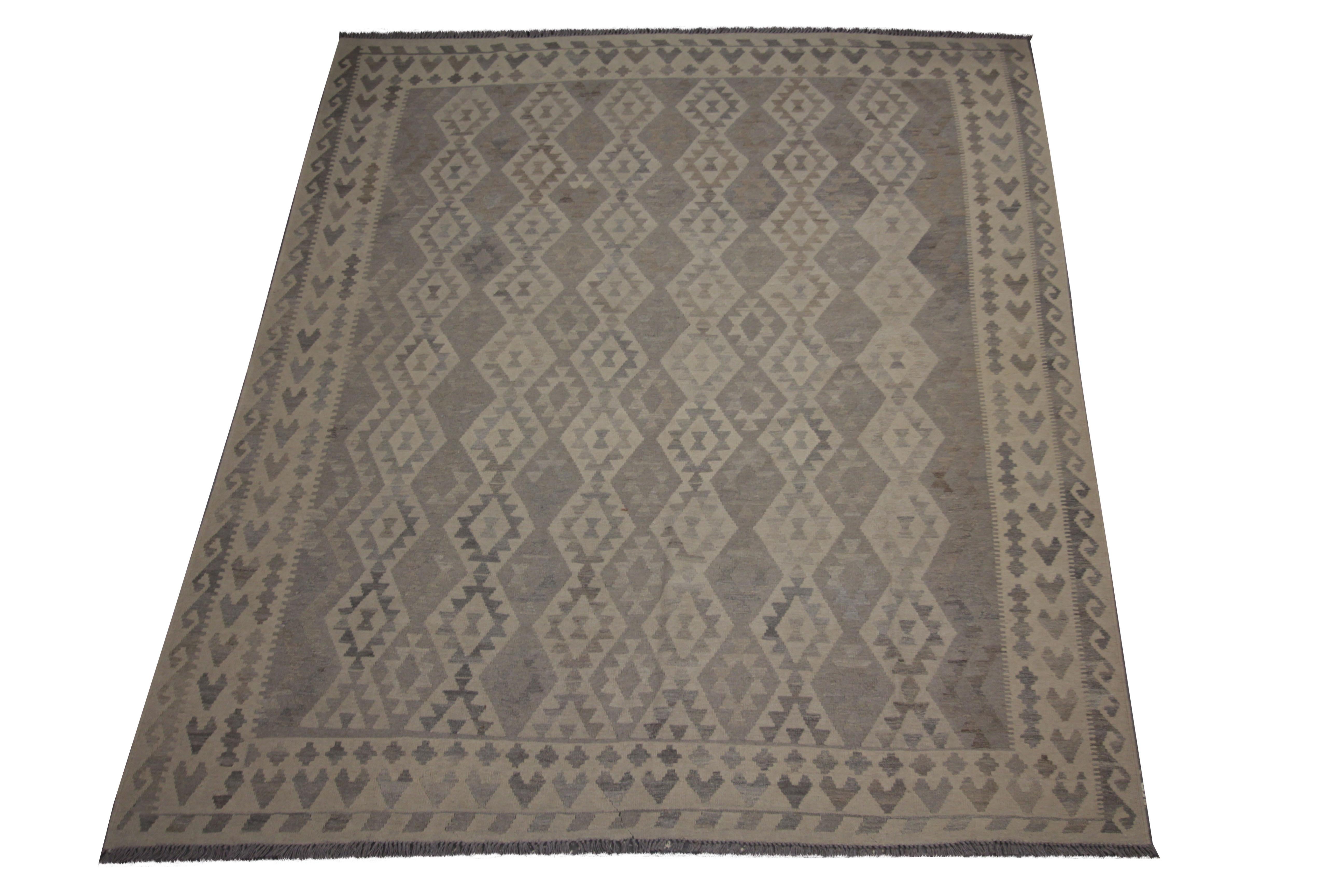 This fine wool rug was woven by hand in Afghanistan in the early late 20th early 21st century. The design has been woven with a traditional geometric pattern featuring diamond motifs woven in a repeating design. The colour palette makes it easily