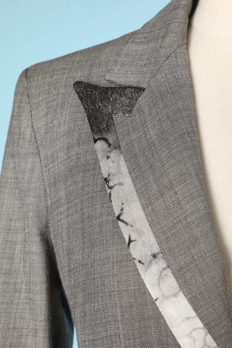 Blazer croisé en laine grise avec bord en soie imprimée et boutons en velours noir. Hologramme d'authenticité. Des pads d'épaule. Marque métallique sur la poche gauche.
TAILLE 44 (It) 40 (FR) L (US)