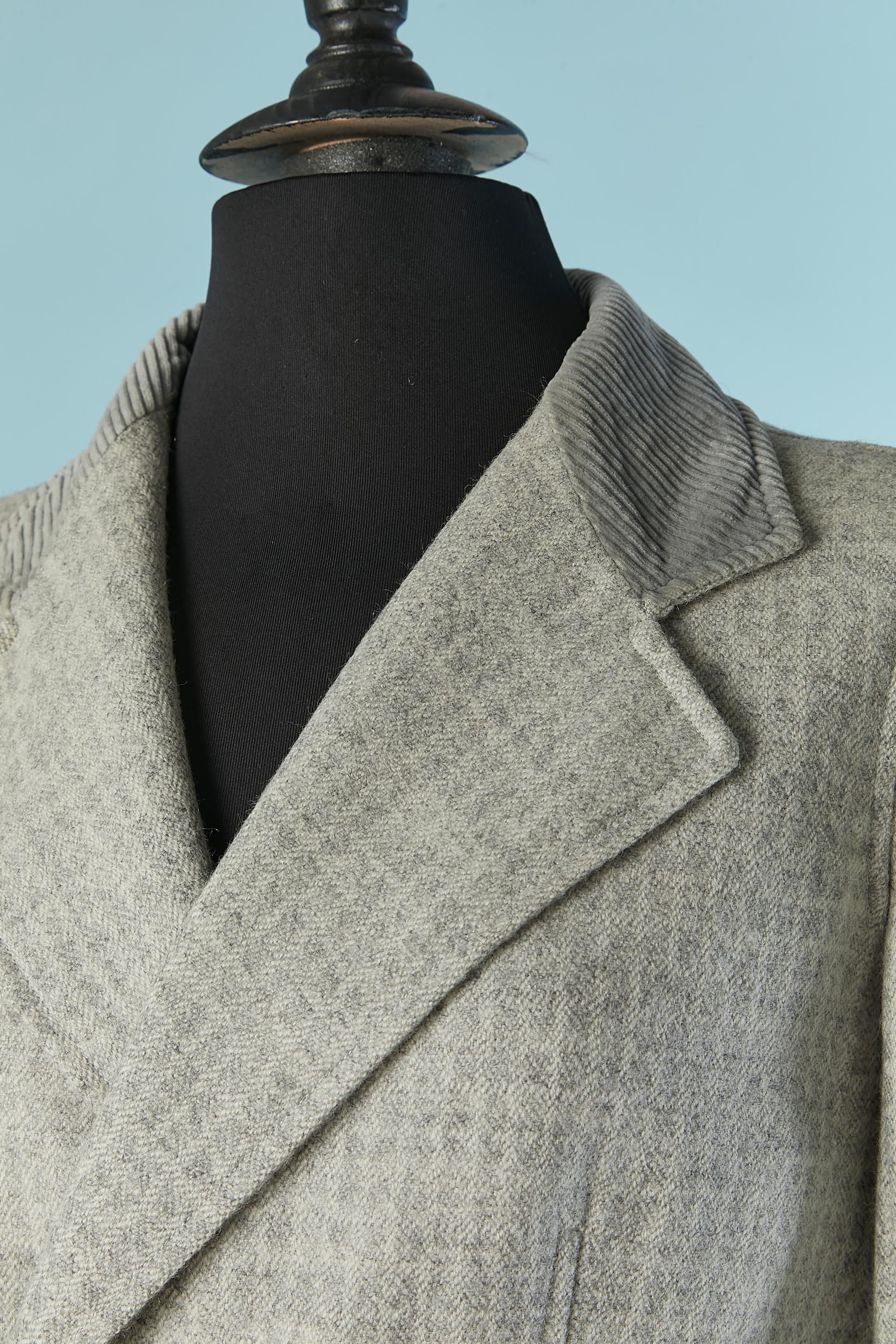 Grauer Woll-Rockanzug mit zweireihiger Jacke und Cordkragen. Futter aus Acetat.
Holzknopf und Knopflochverschluss auf der Vorderseite der Jacke. Tasche auf beiden Seiten, halber Gürtel auf dem Rücken mit Holzschnalle.
SIZE 38 (Fr) M 