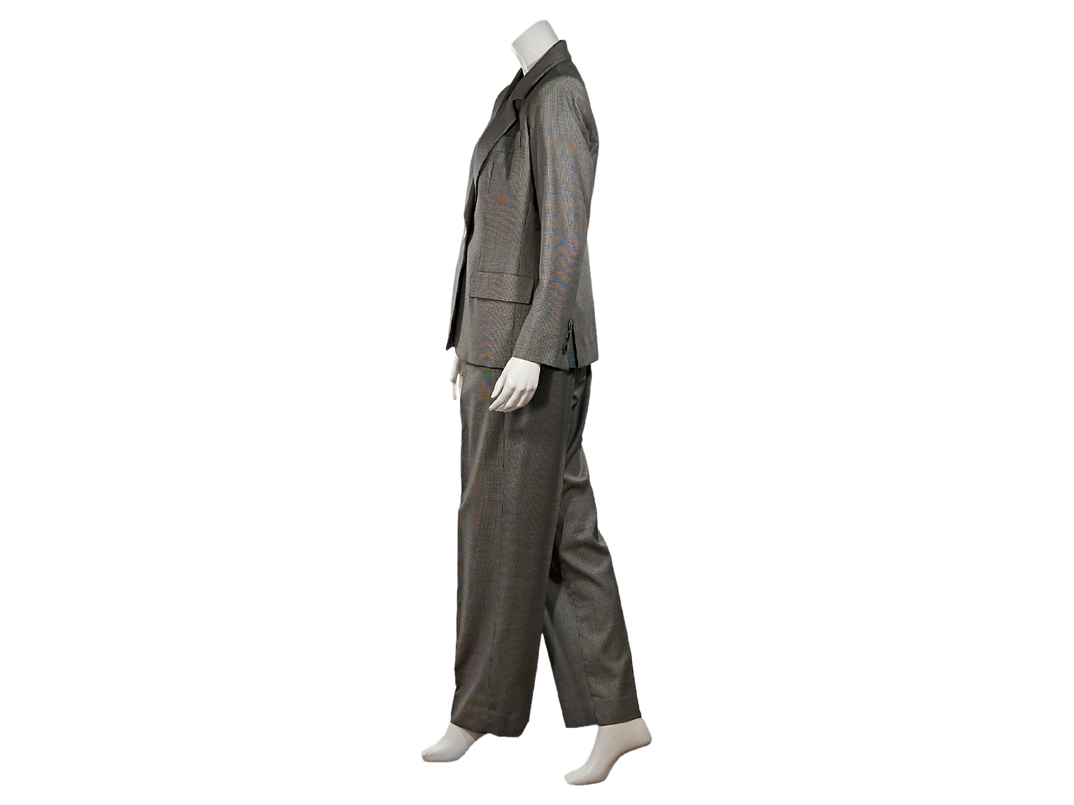 Product details:  Grey houndstooth 3-piece wool suit by Yves Saint Laurent.  Circa the 1990s.  Notched lapel.  Long sleeves.  Three-button detail at cuffs.  Single-button closure.  Besom chest pocket.  Waist flap pockets.  Matching vest. 