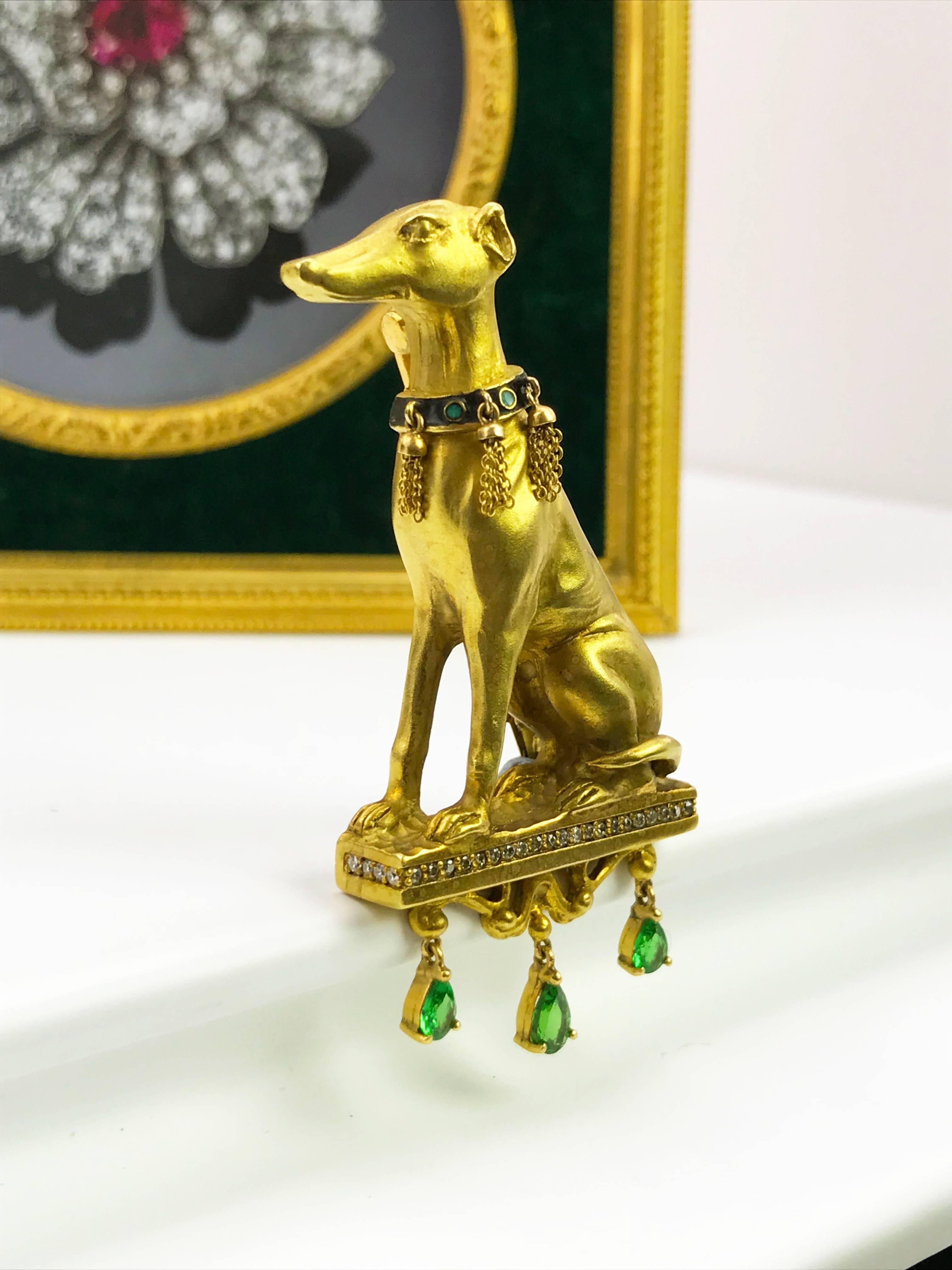 A 18ct gold greyhound diamond and tsavorite garnet brooch. Designed as a seated greyhound with green enamel and tassel collar, atop a brilliant-cut diamond line pedestal, suspending a pear-shape tsavorite garnet fringe. Estimated total diamond