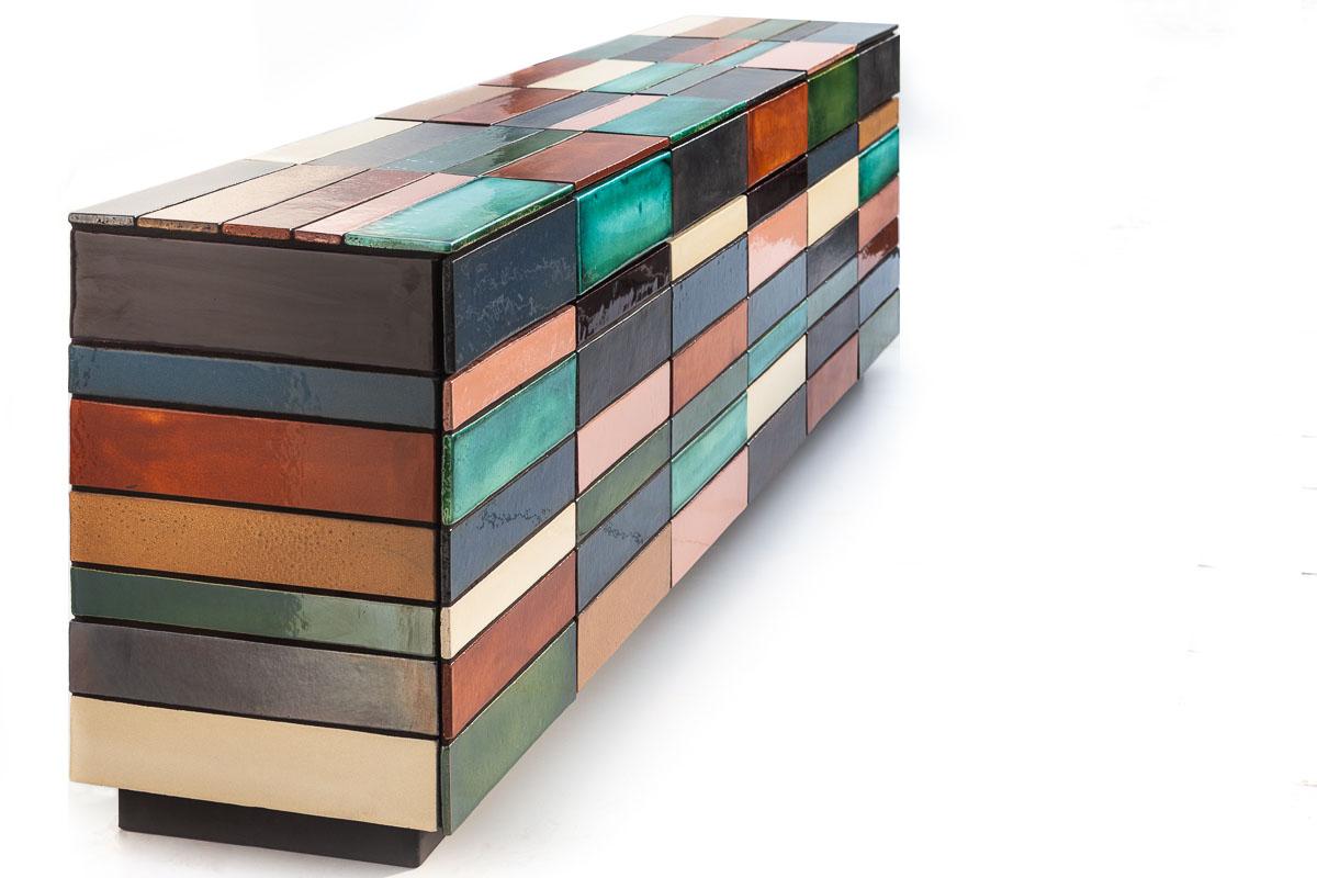 Barren, colorful and unpredictable. The surprising line play and natural shine of ceramics make Grid a sideboard without previous. The invisible base in high-grade wood is finished with a multitude of geometric shapes and color shades. Apparent