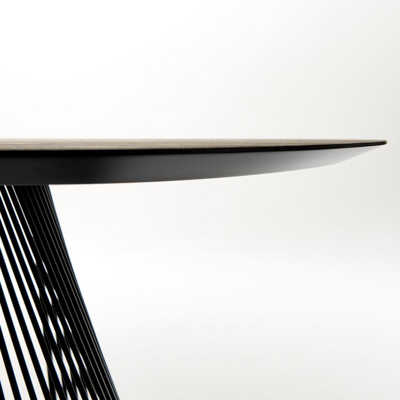 Cette table sculpturale affiche une silhouette d'un dynamisme exceptionnel qui ne passera pas inaperçue. Le plateau rectangulaire fini avec du durmast canadien et marqué par des bords biseautés, présente des angles arrondis qui s'harmonisent avec