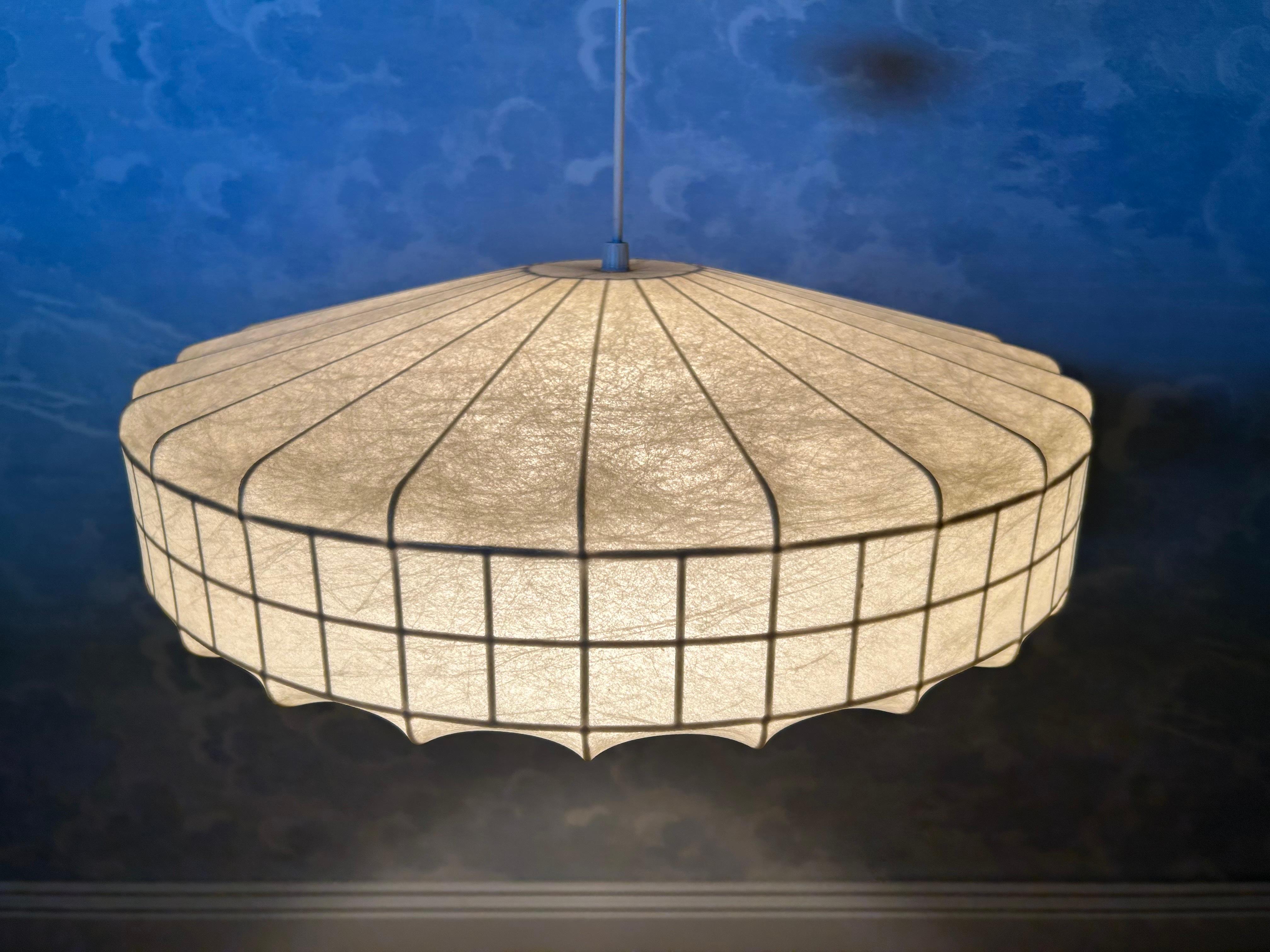This is unusually shaped cocoon light fixture glows in a warm, champagne colored light making it  perfect for creating an intimate and refined space. The grid-like frame around the central cylinder makes this cocoon a rare find - we have not found
