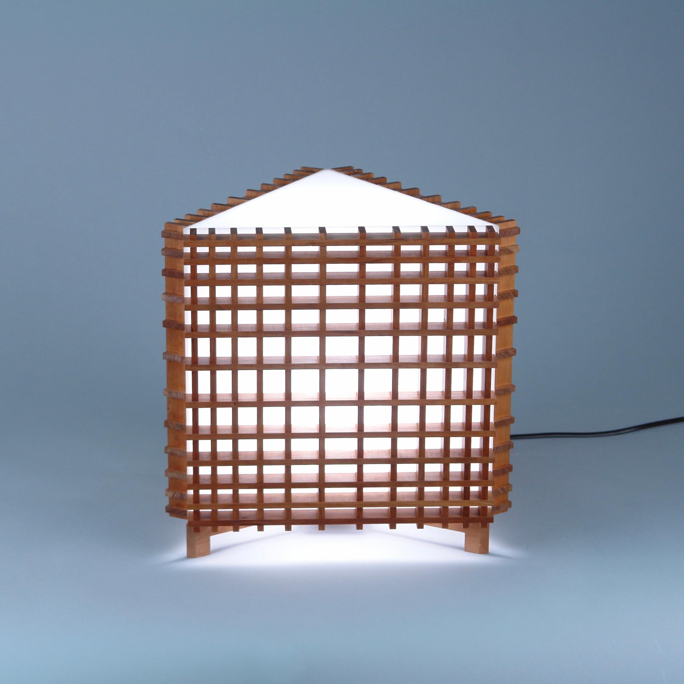Grid Tri6 table lamp in Scandinavian and Japanese influenced Contemporary style. Cherry and Acrylic.
The rectilinear forms of the diminishing grid give a paradoxical illusion of circularity, of foreground and background.
Electric components UL