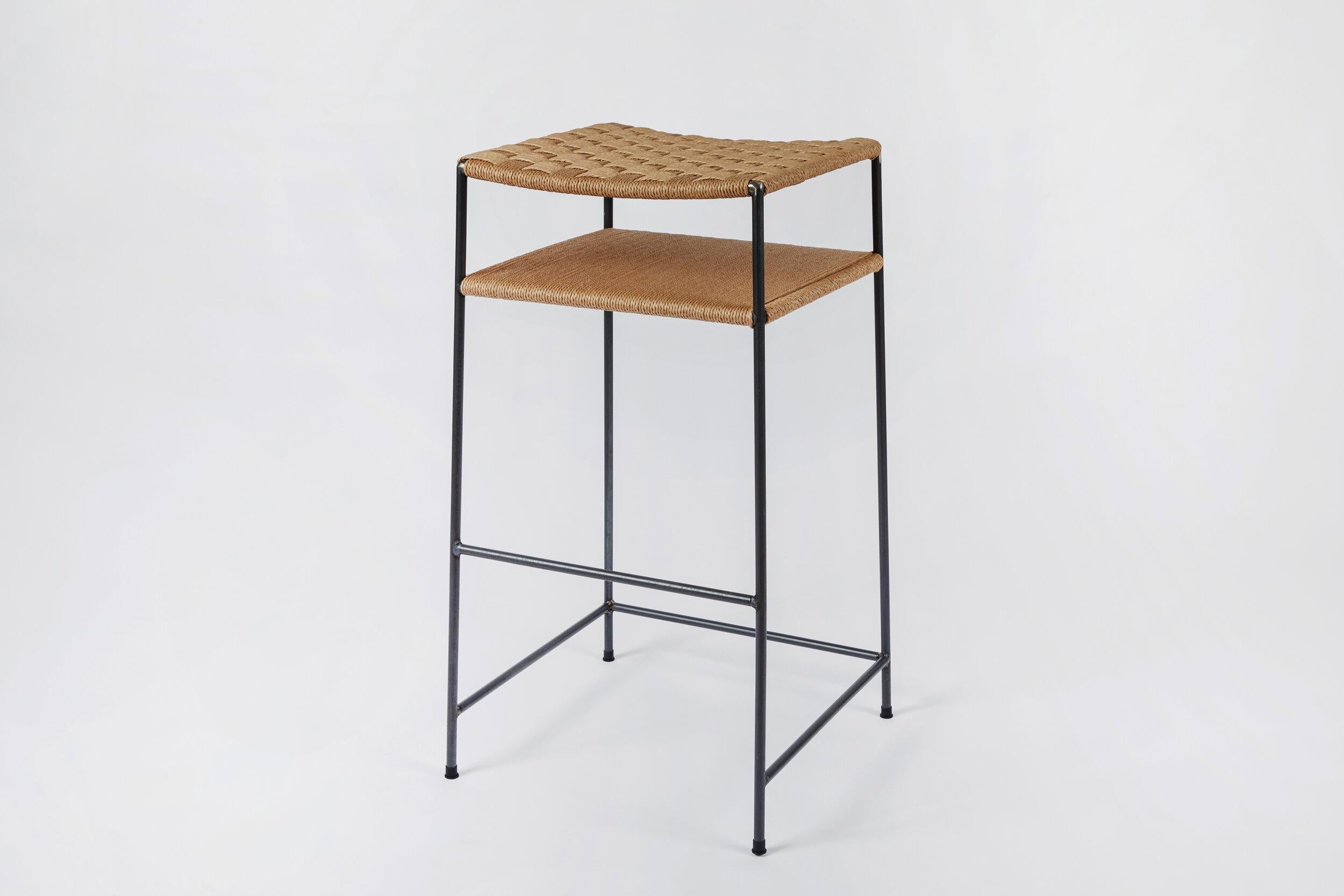 The rush seat and shelf are hand-woven by a master weaver with over 40 years experience.

We use 70% recycled steel for the frame. For an additional charge the frames can be plated in bronze, polished nickel, or brushed nickel. 

Designed by a
