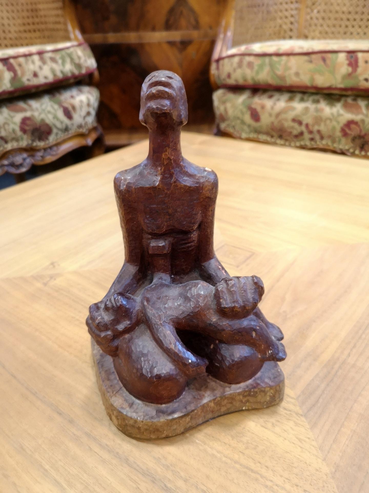 From hand carved fruitwood, this sculpture depicts a dramatic scene of a parent holding a child. The sculpture is signed on the back 