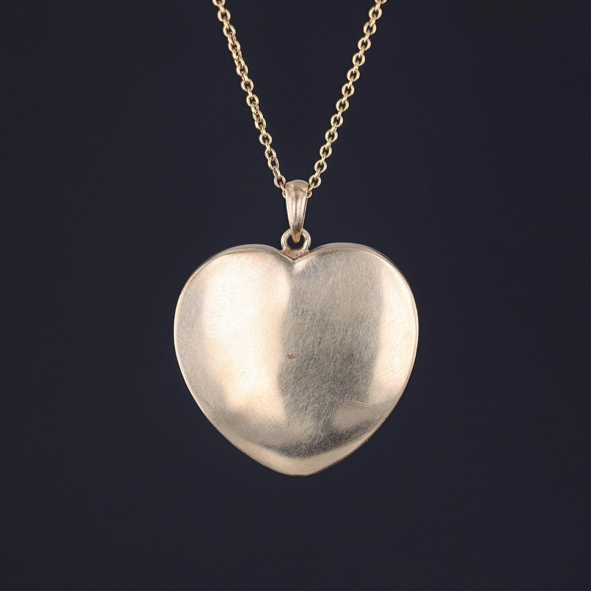 This pendant features an onyx heart adorned with a tricolor gold griffin holding a pearl in its tail.

Our jeweler created this unique piece by riveting the griffin from an antique stickpin (circa 1900) onto a vintage onyx heart and mounting the