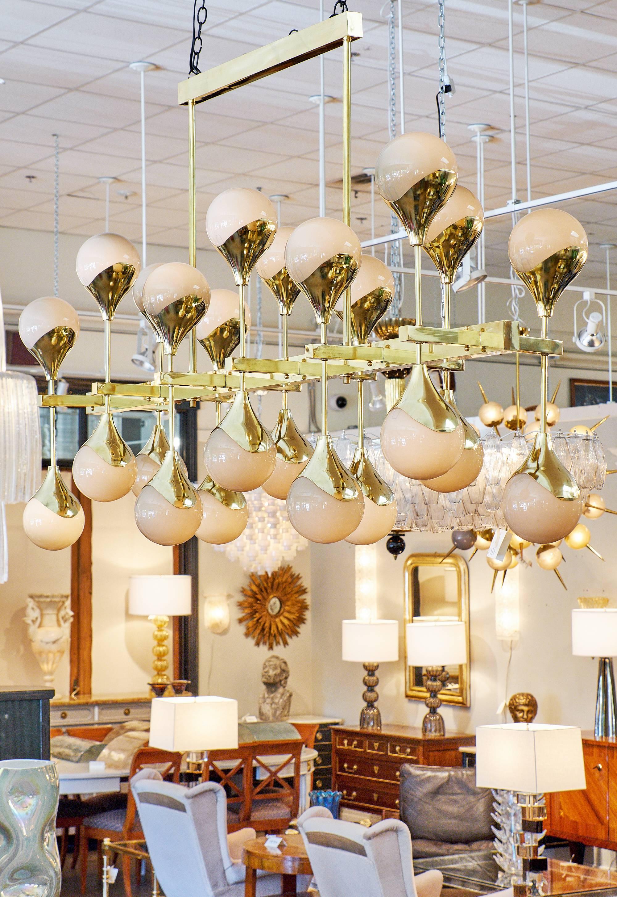 Meraviglioso lampadario in vetro di Murano importante alla maniera dello Stilnovo. Le sfere soffiate simili a perle e la struttura in ottone galvanizzato creano una spettacolare scultura luminosa. Questo pezzo ha 24 steli con luci e la lavorazione è