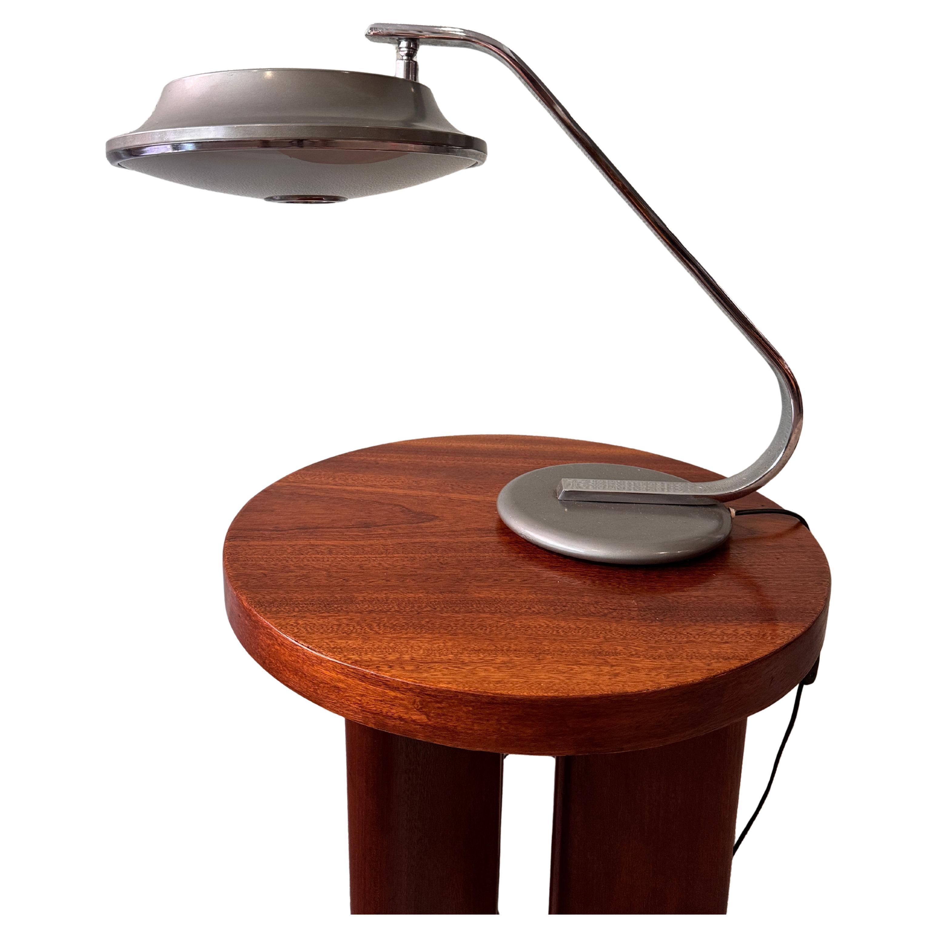 The Grin Luz Table Lamp, designed by Luis Pérez de la Oliva in the 1970s, is a distinctive variation on the earlier 520C model, showcasing a bold departure in design. This version features a unique hat-shaped shade and an arm with a more pronounced