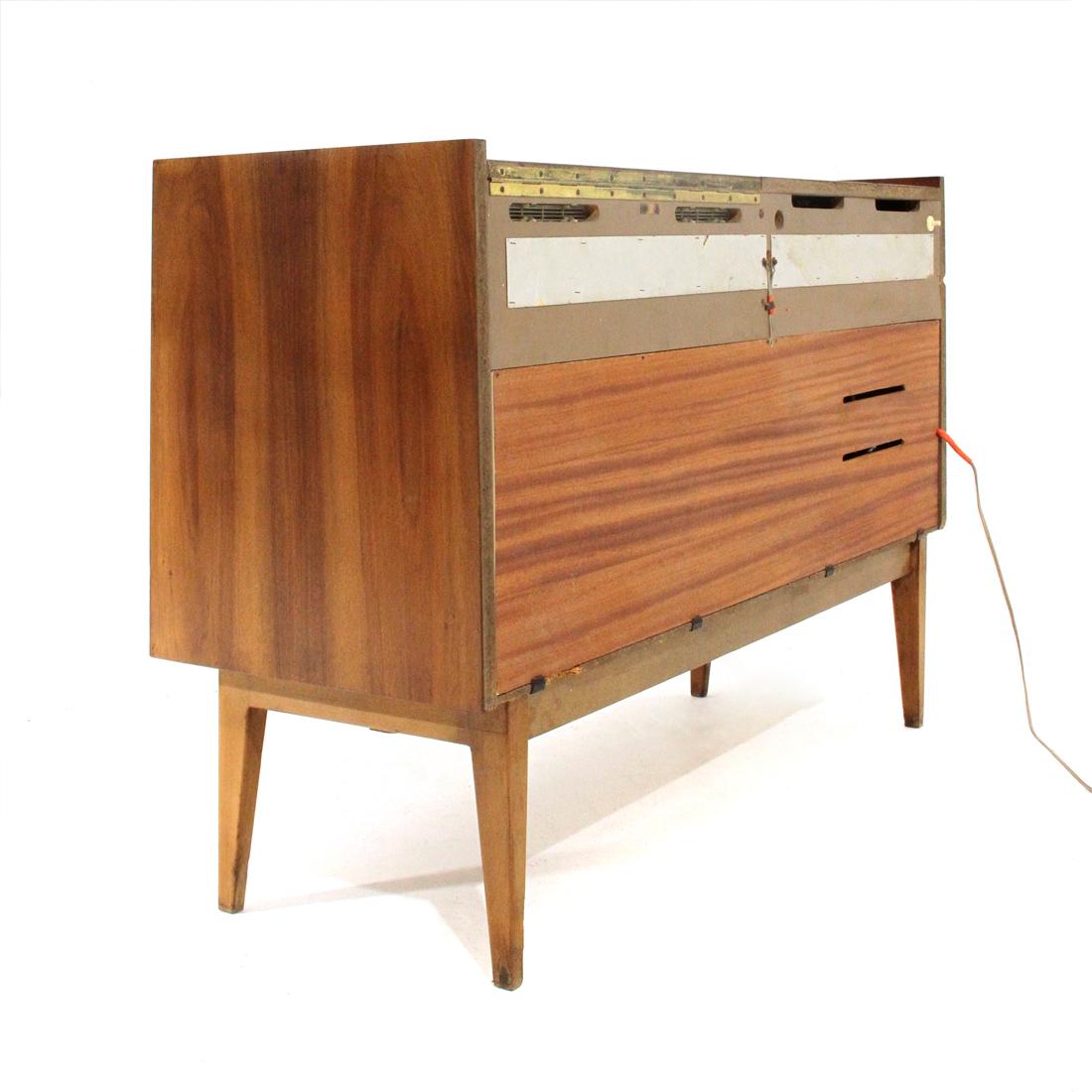Stereo cabinet produced by Grundig in the 1950s.
Structure in teak veneered wood.
Radio with Lw, Mw, Kw, Ukw frequencies.
Turntable compartment with disc holder and light.
Auxiliary output.
All is working.
Audio speaker net replaced.
Good