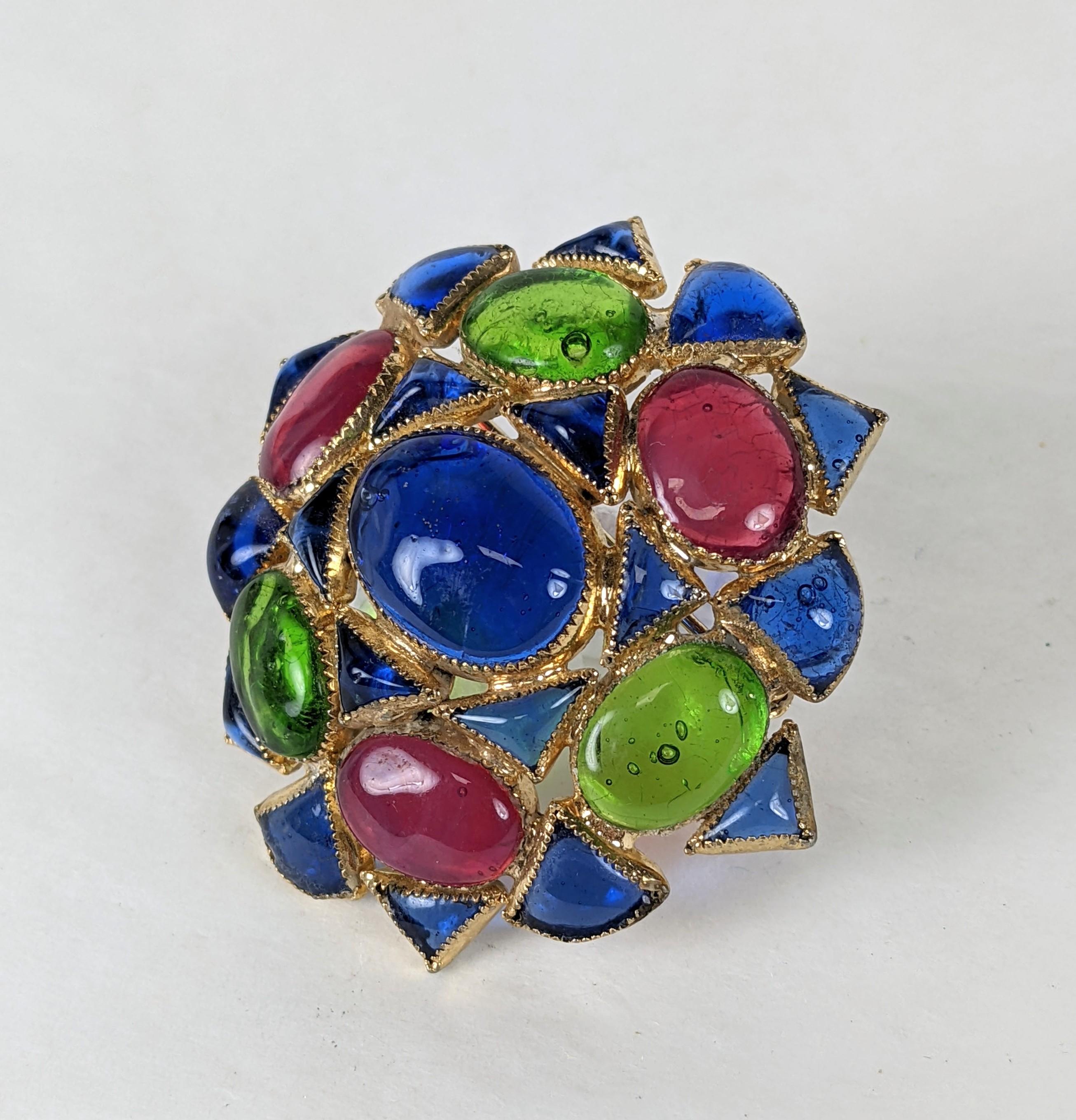 De Nicola Gripoix Glass Anglo Indian crest shape brooch. Composed of pink ruby, emerald and sapphire hand poured glass enamels. A large focal sapphire cabocheon forms the brooches center. 
Various US companies in the period used Maison Gripoix for