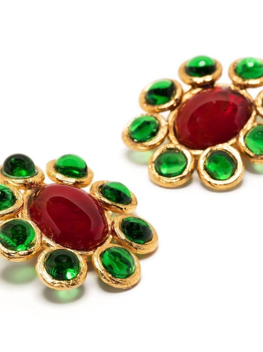 Designed by Gripoix in the style of Chanel, these pre-owned vintage earrings display large green and red cabochons set in a gold-toned metal flower. Secured using a clip-on fastening, these unique earrings can be enjoyed by anyone. Tie your hair