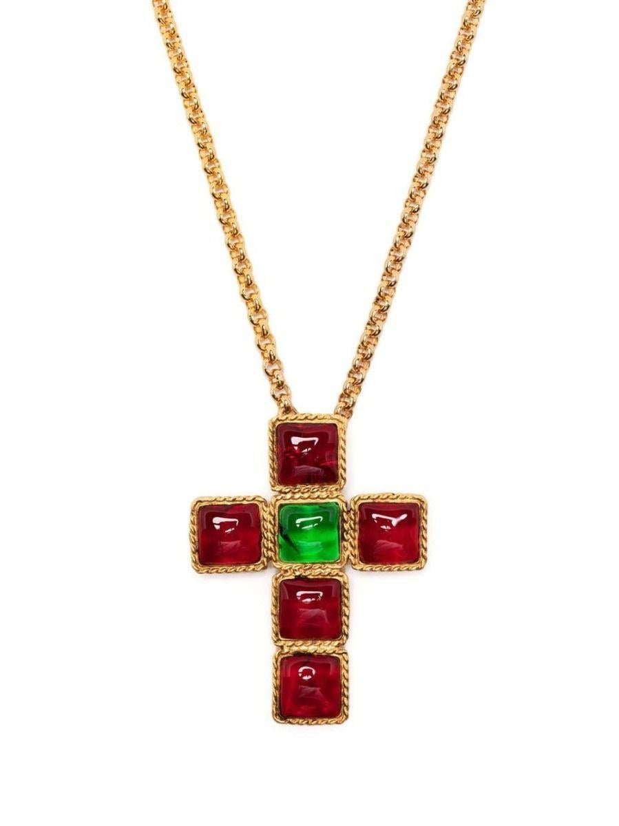 Designed by Gripoix in the style of Chanel, this bold necklace displays a large gold-toned cross motif decorated with red and green cabochons hanging from a chunky gold chain. Secure using a spring ring fastening, this statement piece will uplift